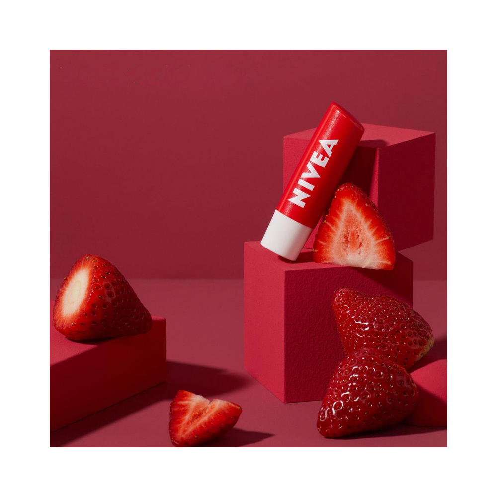 Compact Nivea lip balm tube, highlighted with strawberry imagery and bold branding.