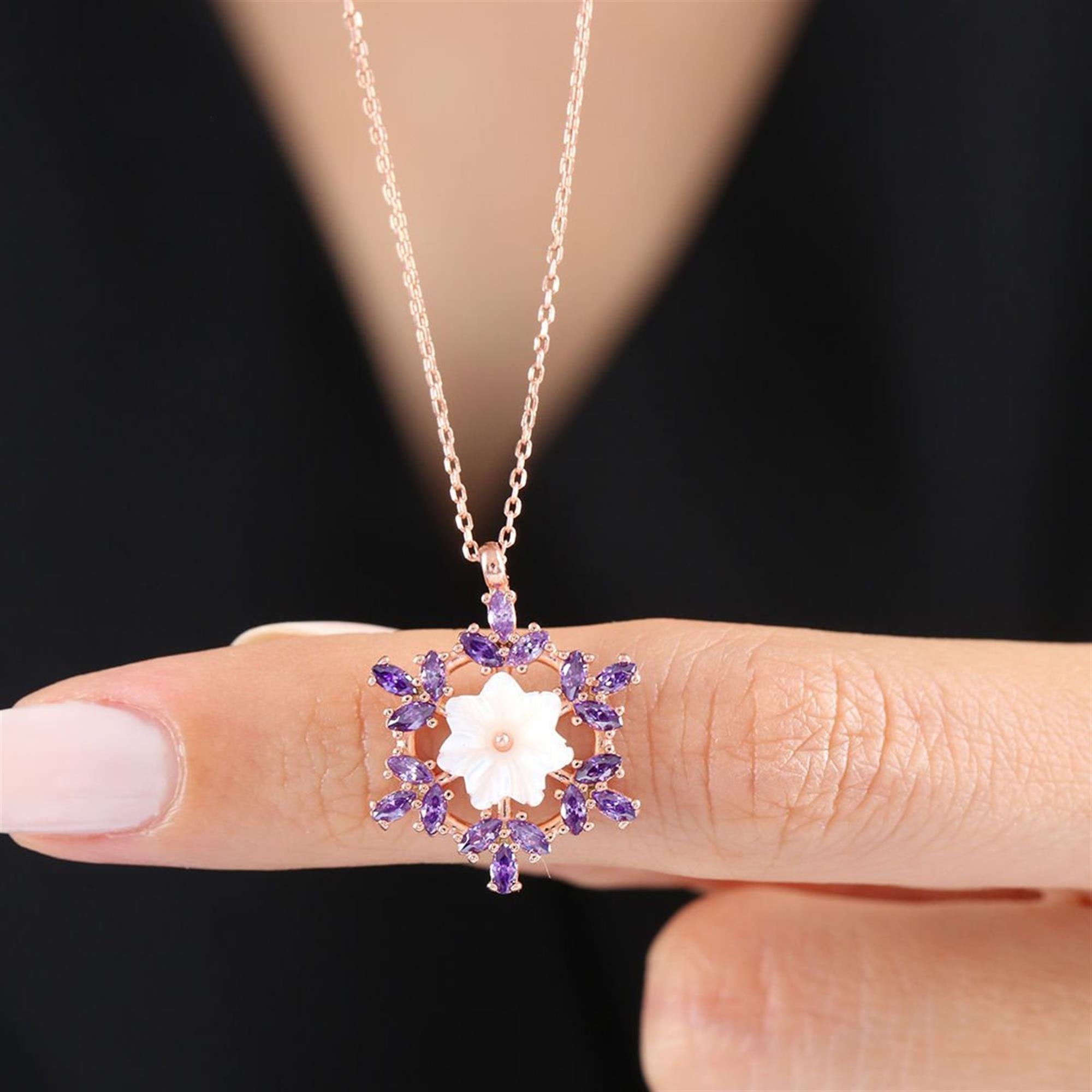 Collar en oro rosa con flor blanca y circonitas amatista en diseño de copo de nieve