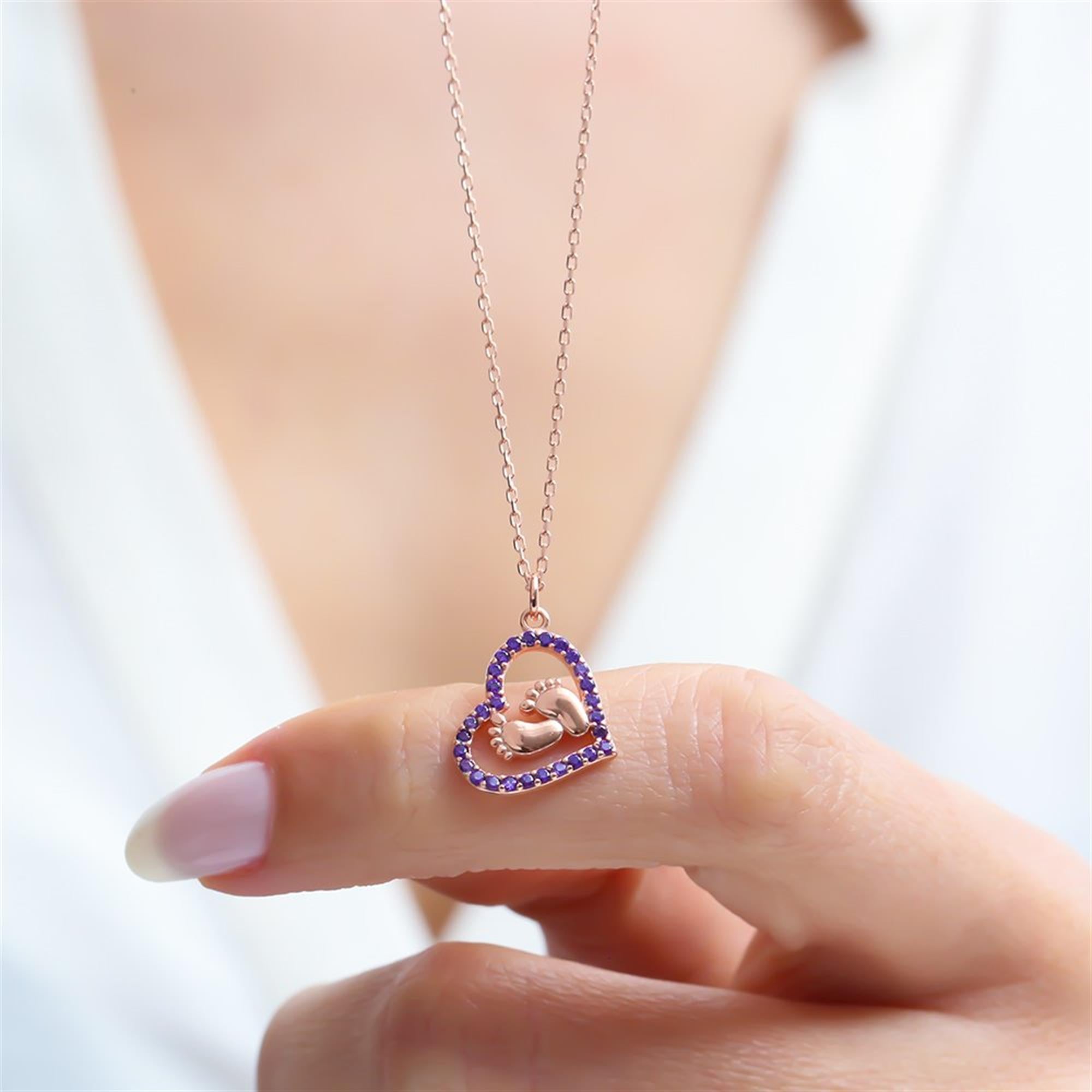 Rose gold heart necklace with baby feet and amethyst zircon stones – symbolic motherhood jewelry in 925 silver.