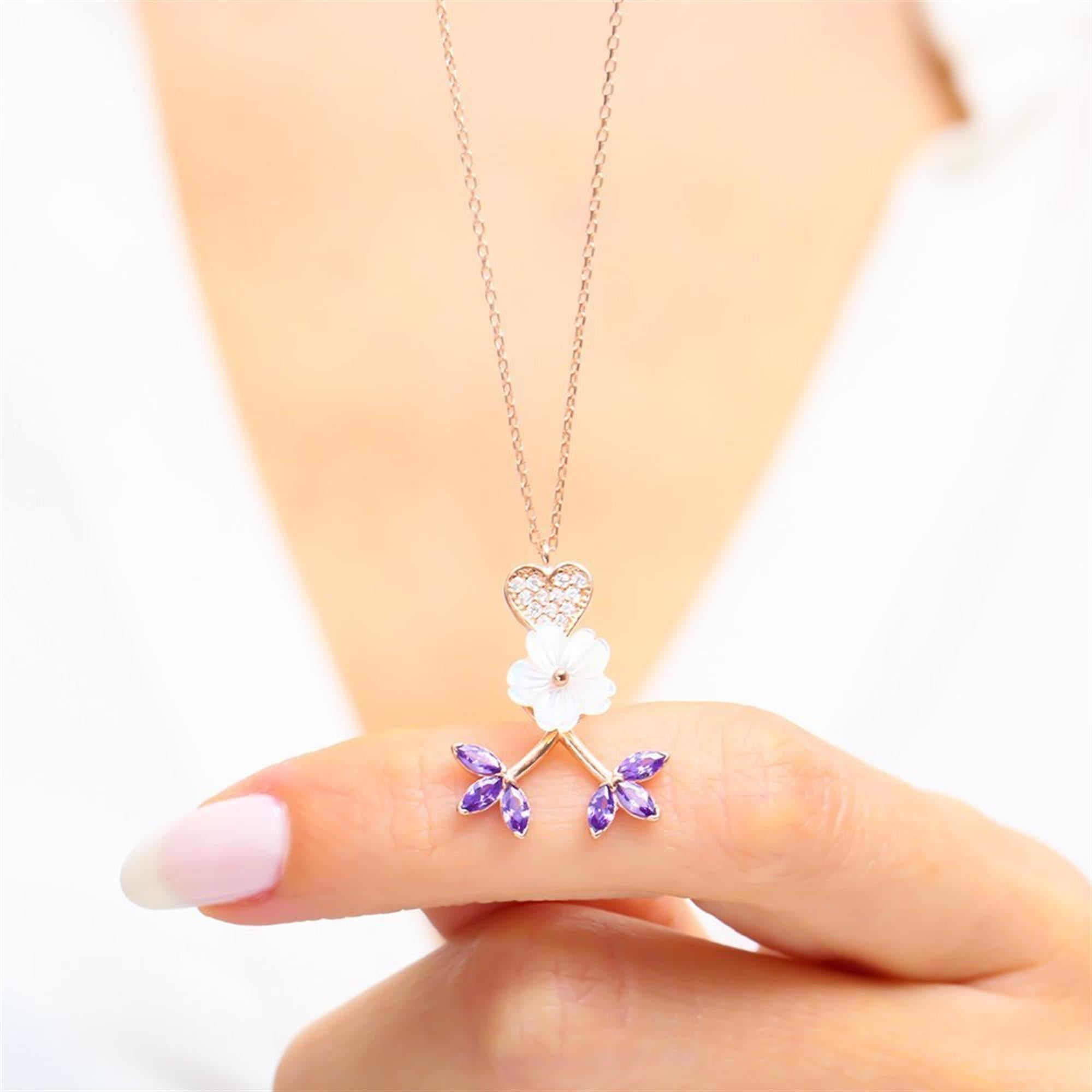 Romantic necklace featuring a rose gold heart, white flower centerpiece, and amethyst leaf charms a blooming symbol of love.