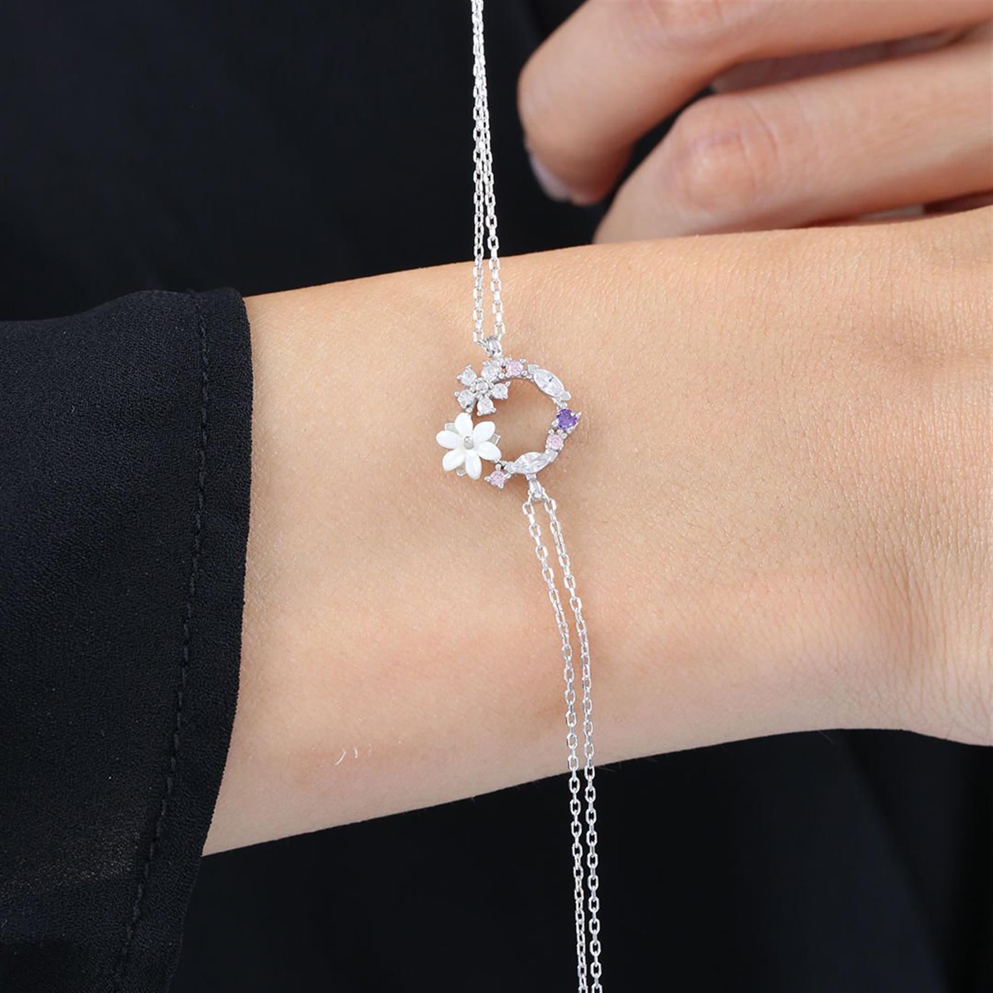 Pulsera de plata con flor de magnolia blanca y círculo floral en tonos púrpura y rosa