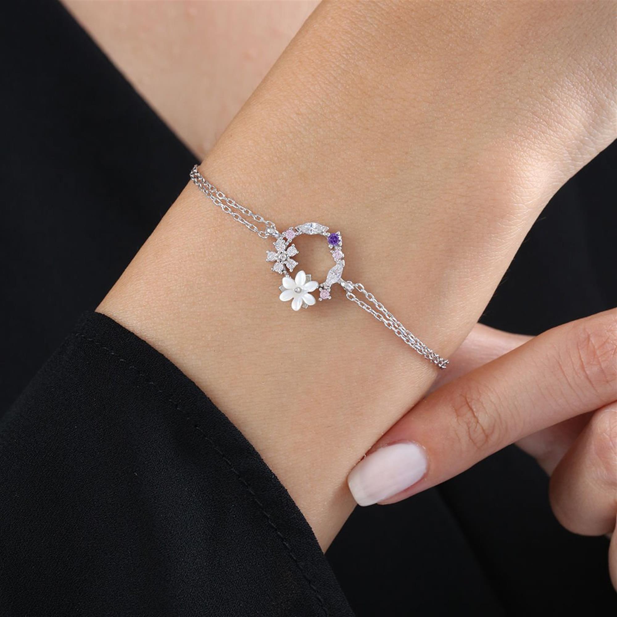 Silver bracelet with white magnolia flower and purple-pink floral circle on a delicate double chain
