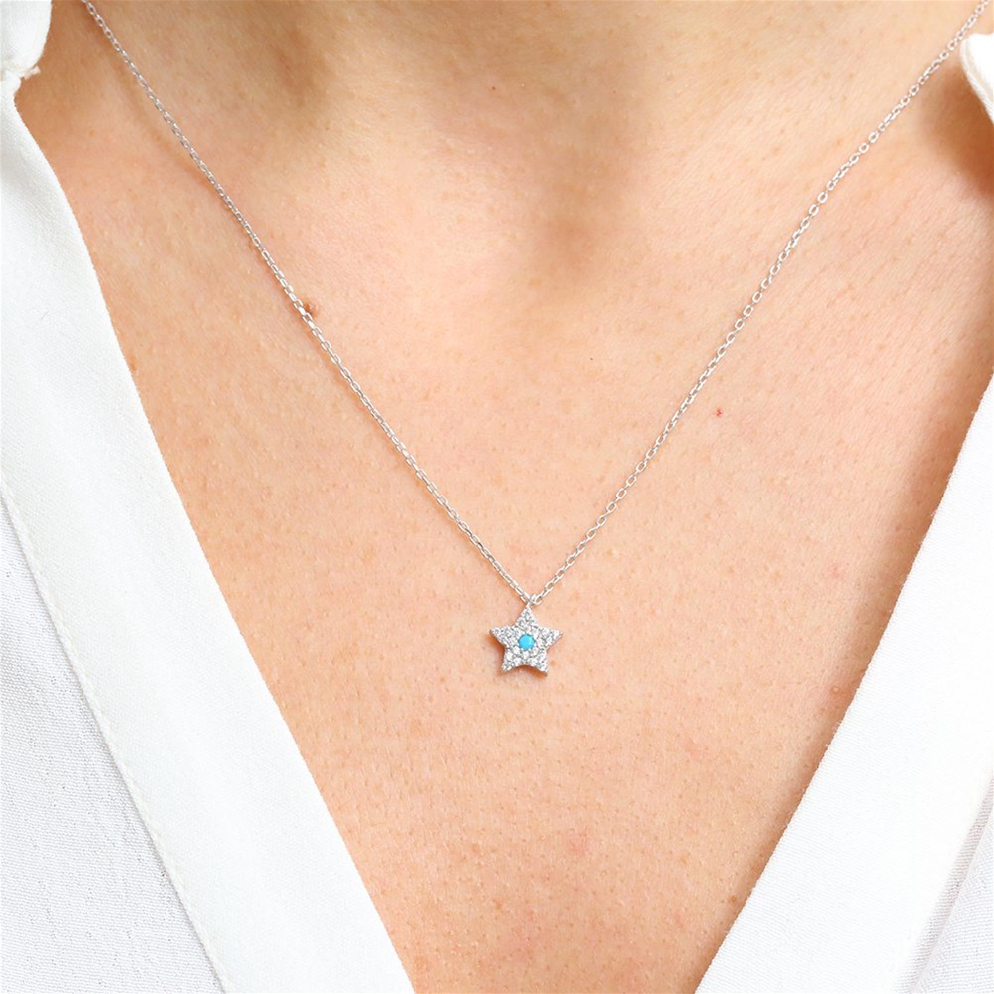Collar de estrella de plata con piedra central turquesa y circonitas brillantes.