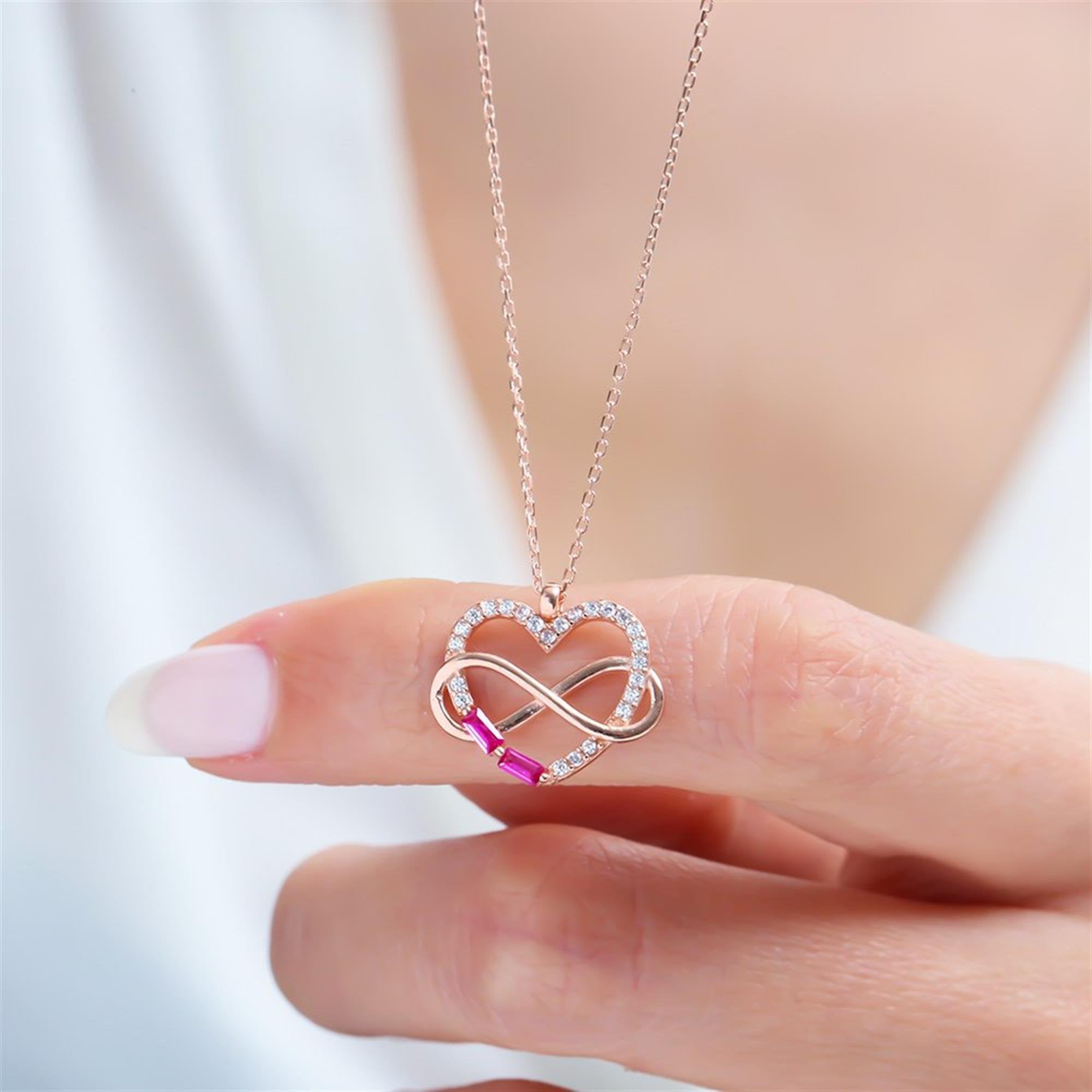 Infinity heart pendant necklace with rose gold plating and fuchsia baguette stones – a symbol of eternal love and elegance.