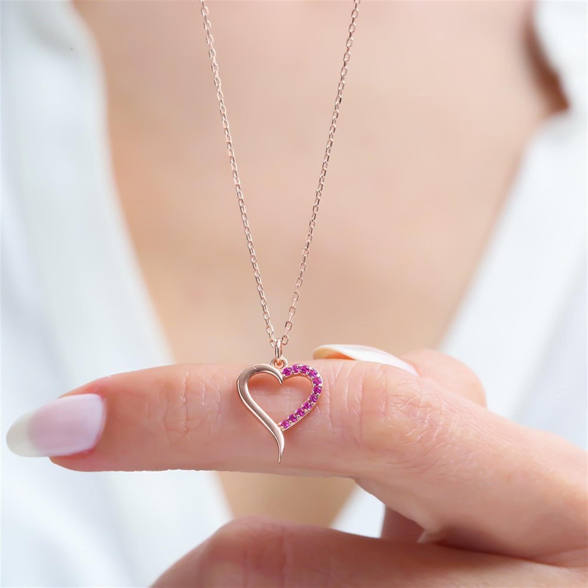 Delicate rose gold heart necklace with fuchsia zircon stones – elegant open-heart pendant symbolizing love and charm.