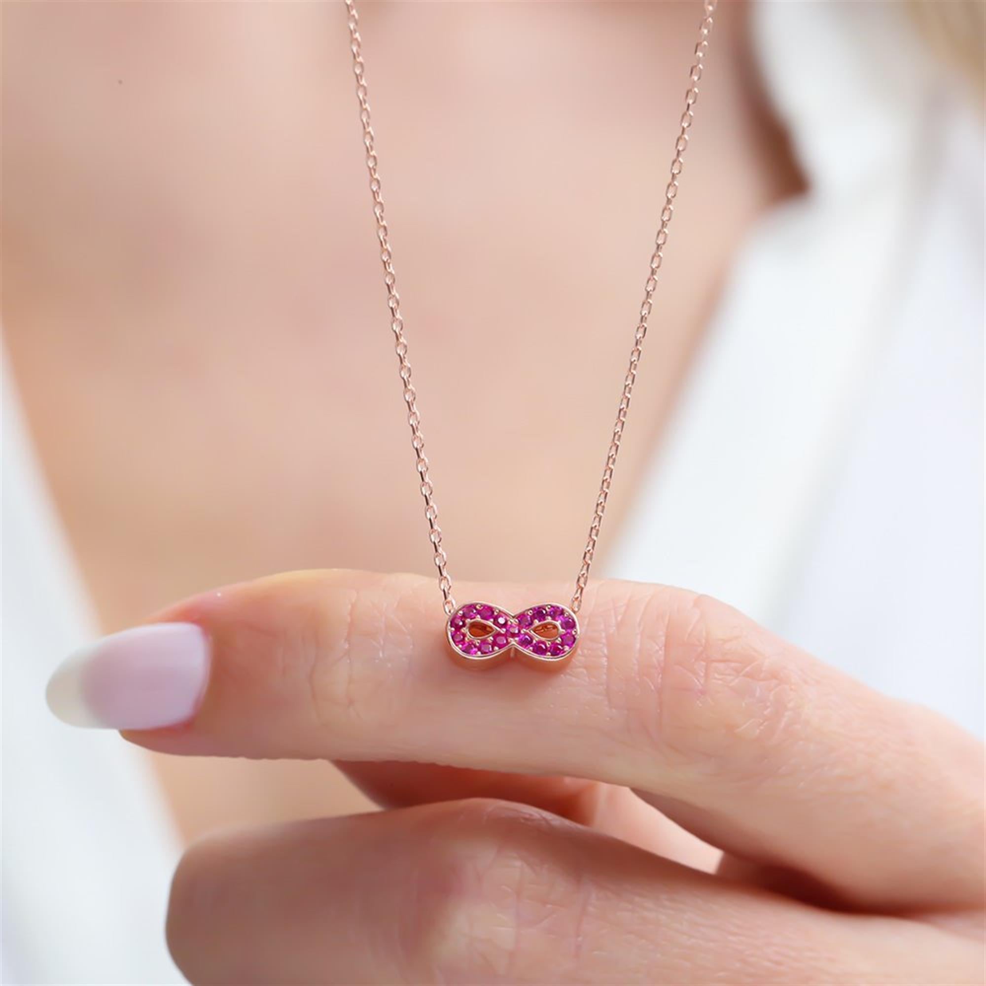 Rose gold infinity necklace with fuchsia zircon stones, symbolizing eternal love and connection – perfect for daily or gift use.
