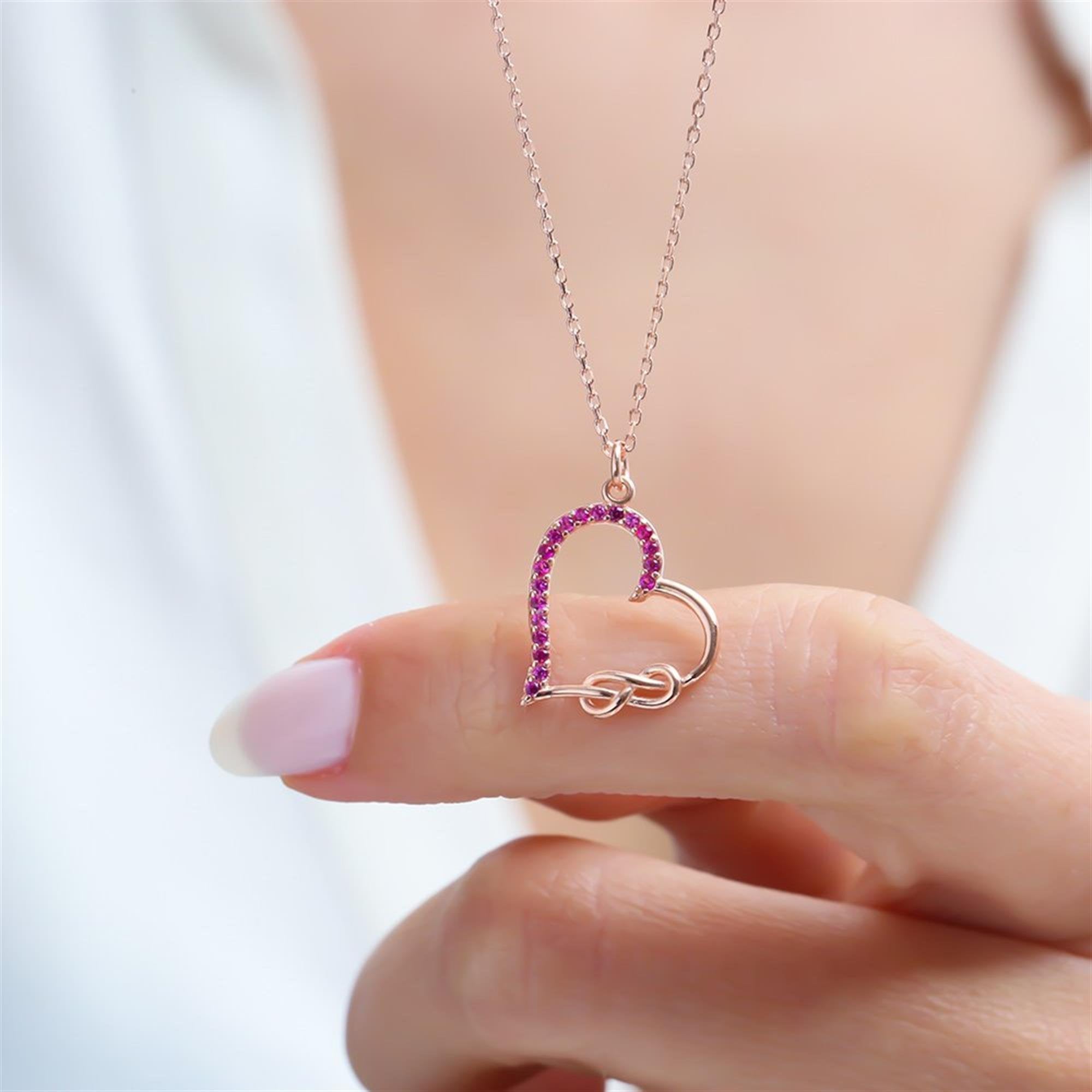 Rose gold heart necklace with infinity knot and fuchsia stones – a perfect symbol of eternal love.