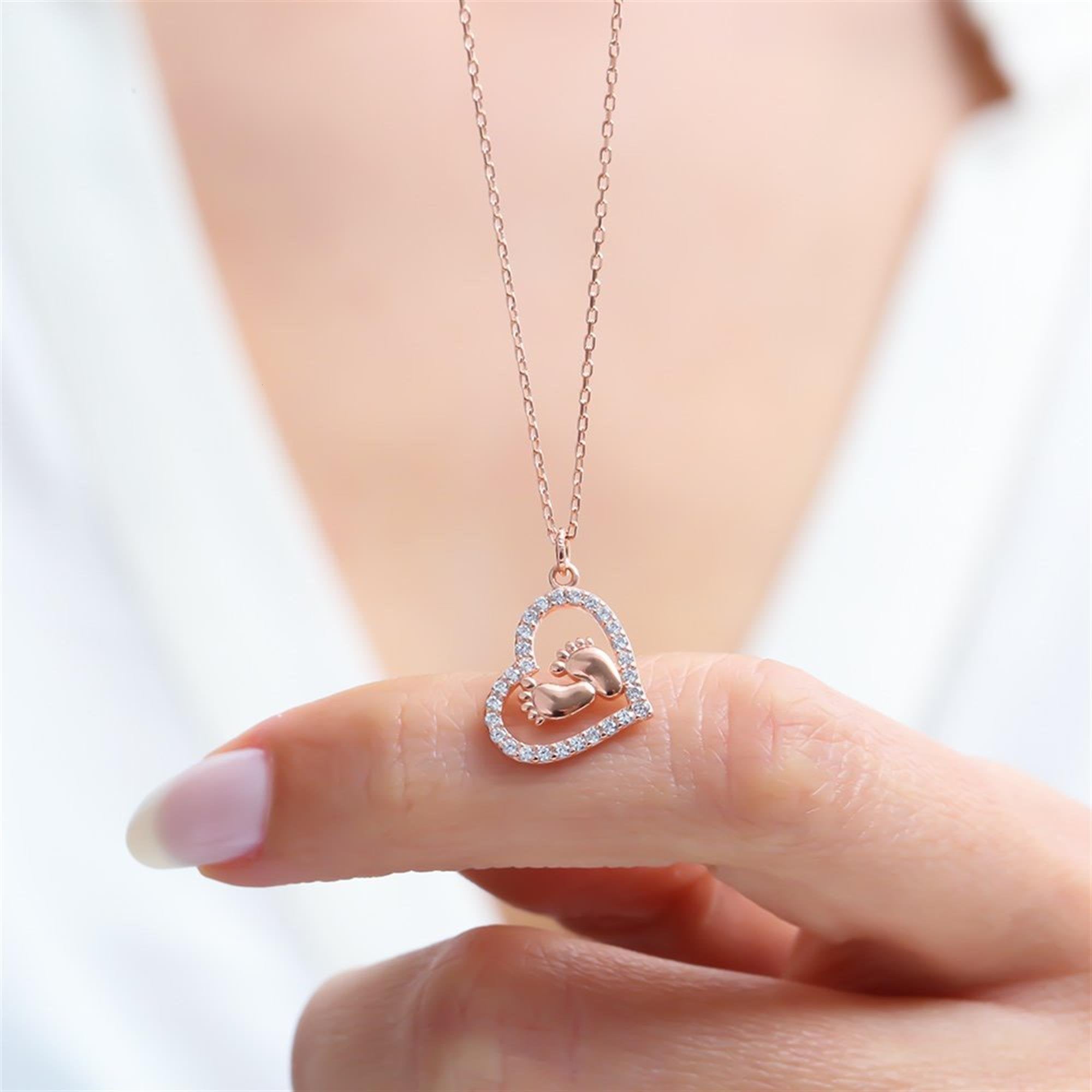 Rose gold heart necklace with baby feet and zircon stones – symbolic motherhood jewelry in 925 silver.