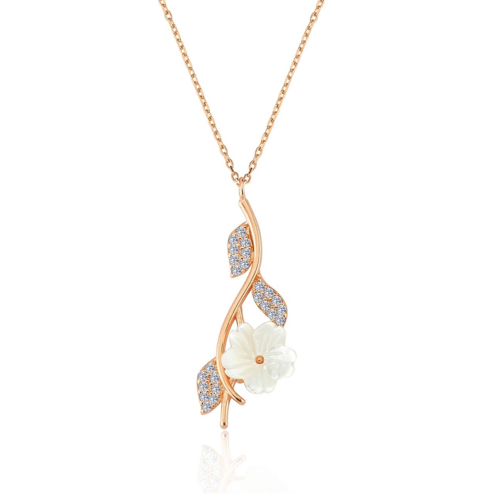 Rose gold necklace with white magnolia flower and three crystal-studded leaves on a curved branch