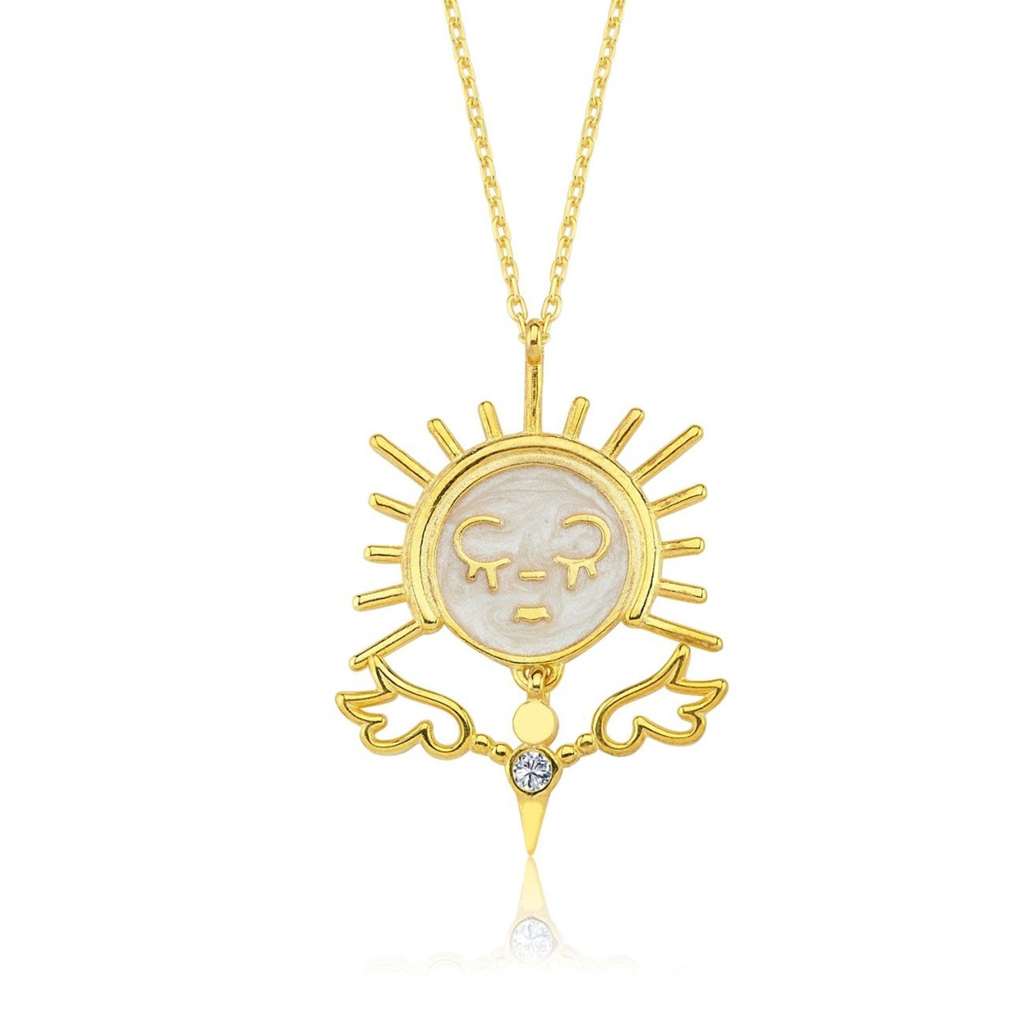 Colgante de sol chapado en oro con alas de ángel y rostro llorando en esmalte, símbolo de emoción pura.