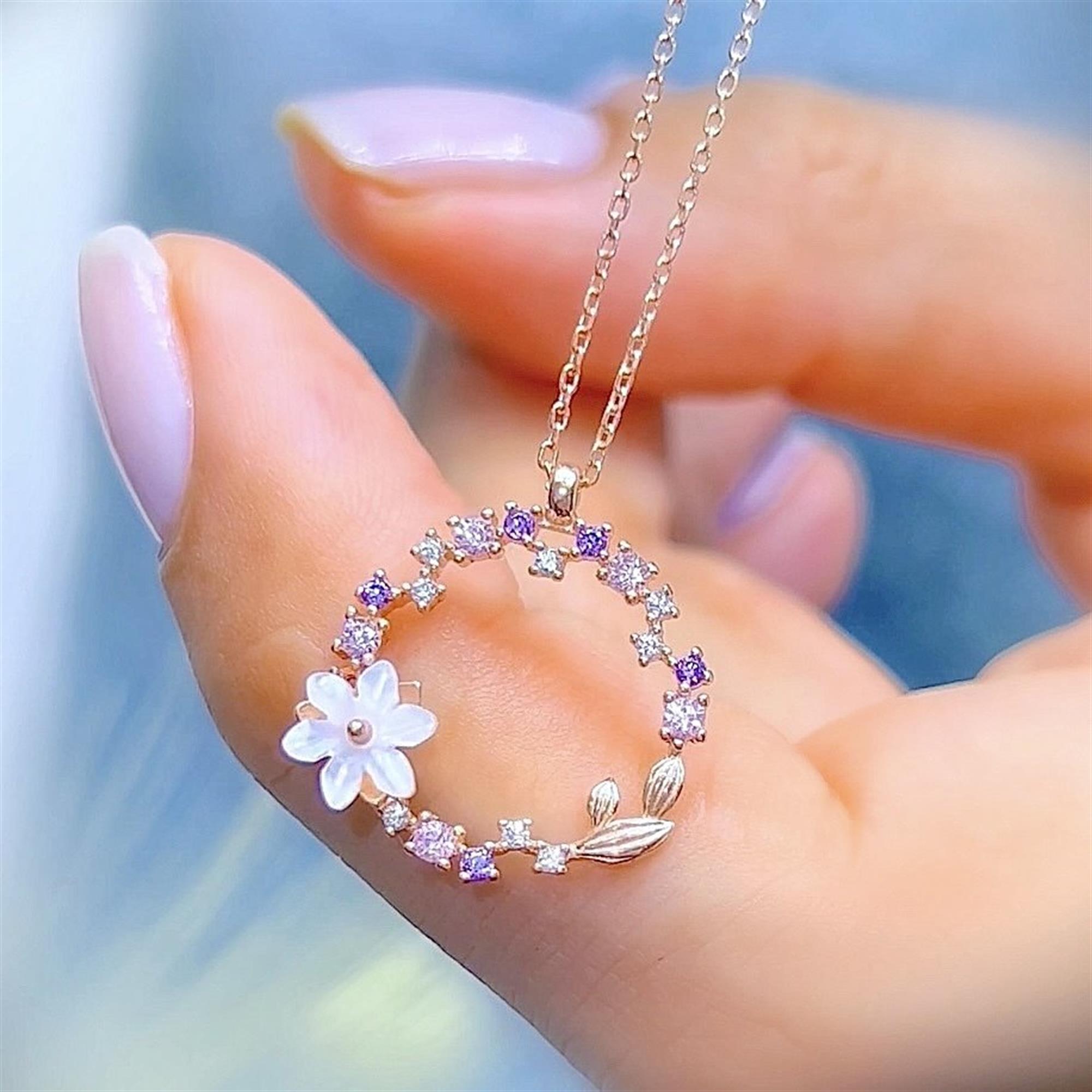 Collar floral con circonitas en tonos pastel y flor de magnolia en oro rosa – ideal para un look romántico.