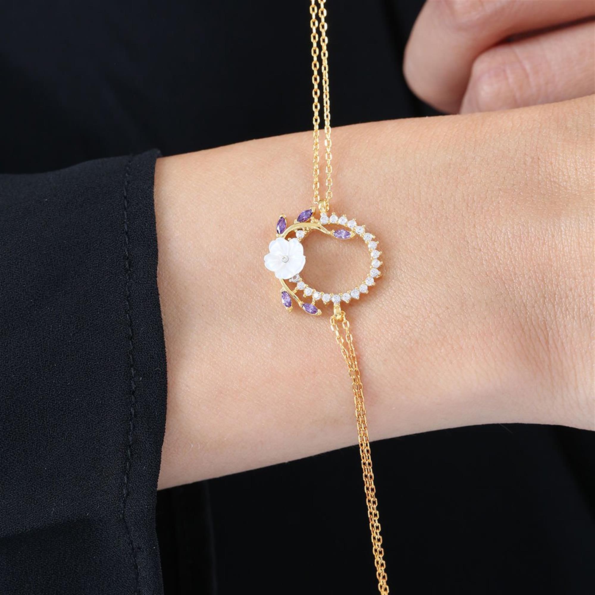 Gold bracelet with circular design, white flower and amethyst stones in leaf shapes