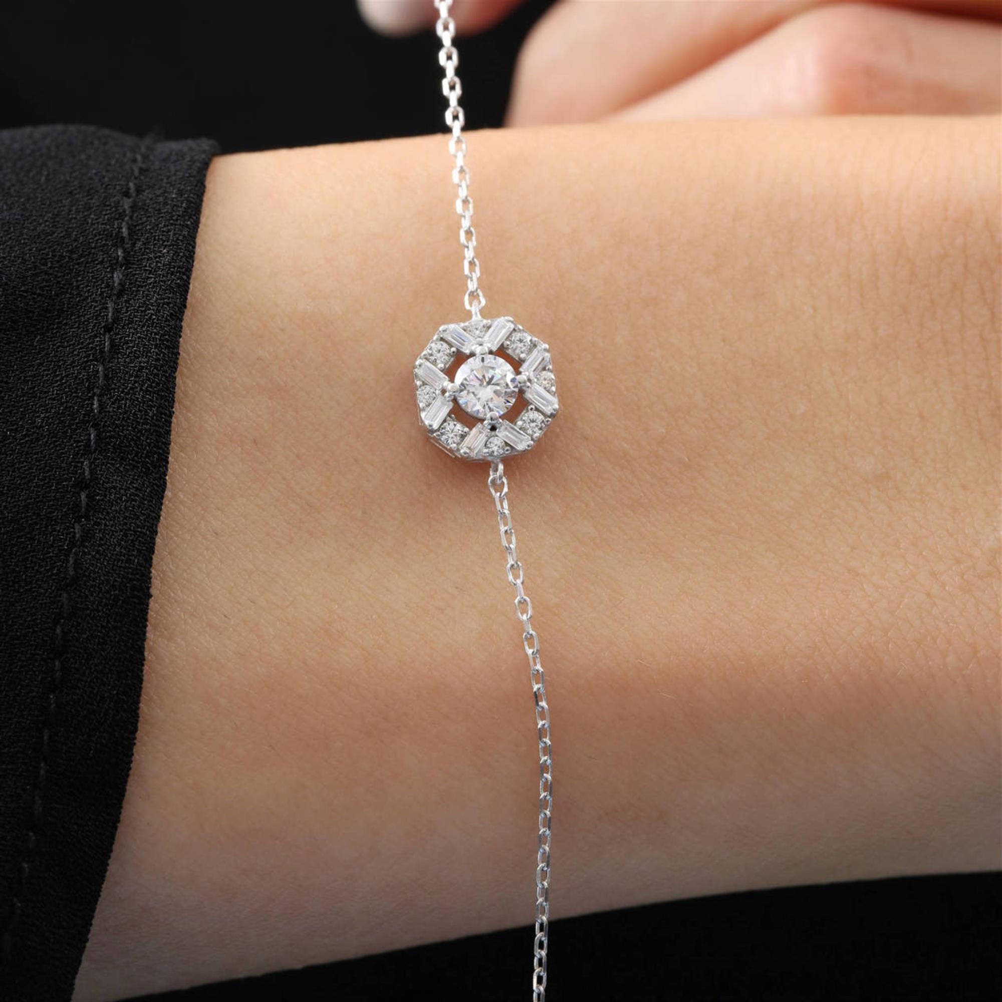 Sterling silver bracelet with round center stone surrounded by baguette-cut zirconia in a halo design