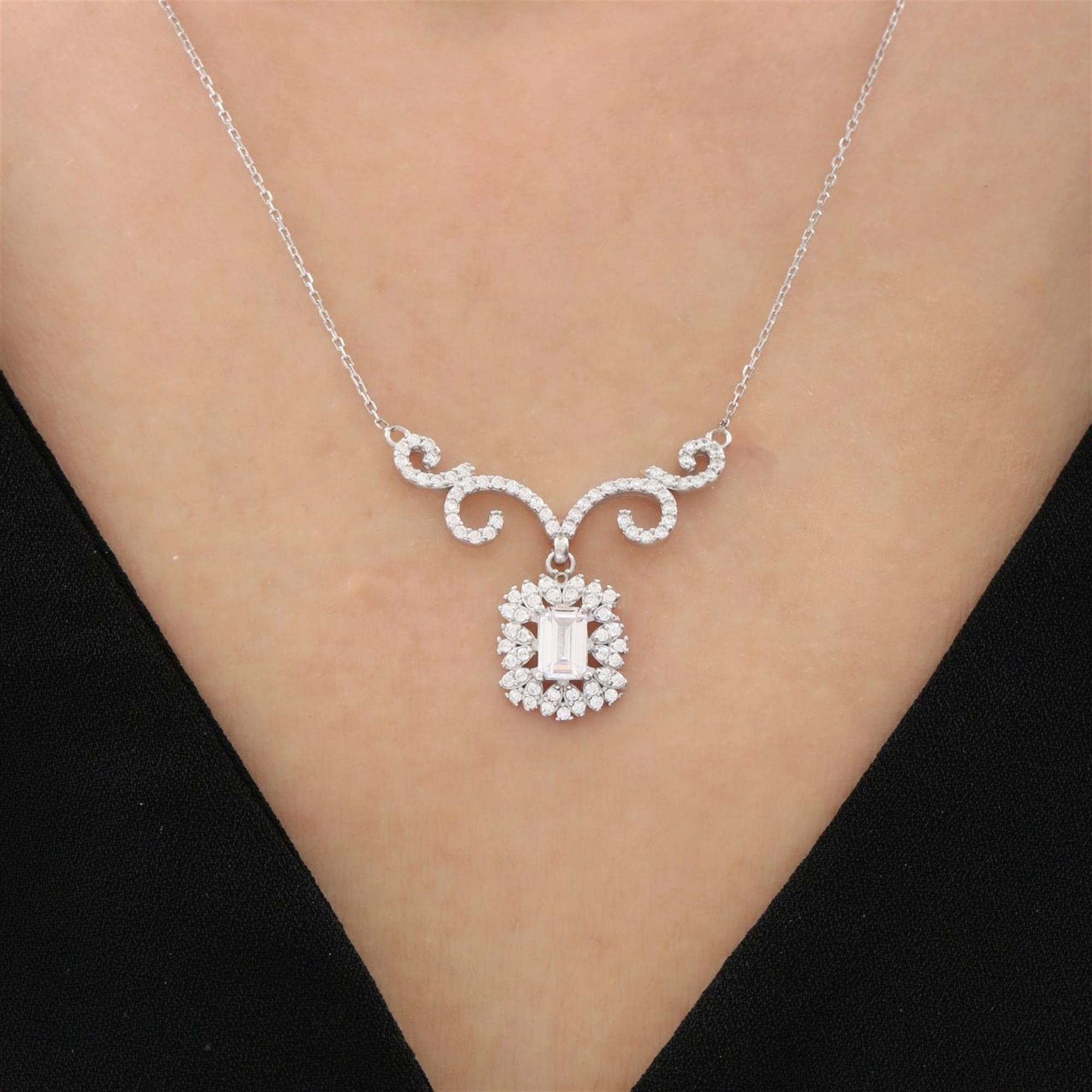 Collar en tono plata de inspiración vintage con una circonita cúbica transparente de corte baguette, rodeada por un halo brillante y decoraciones curvas elegantes – ideal como regalo para mujeres sofisticadas amantes del lujo clásico.