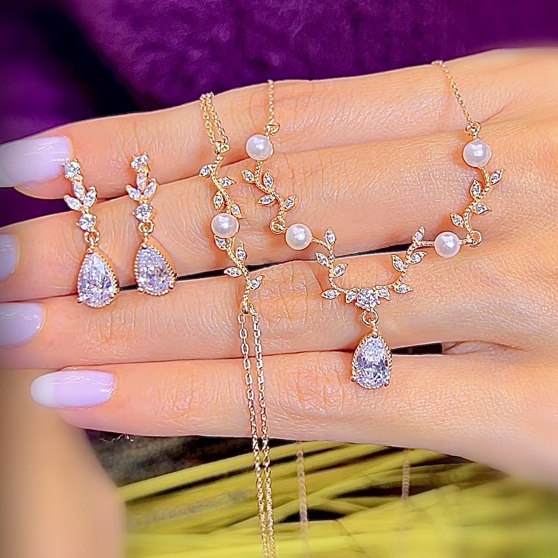 Conjunto de joyas en oro rosa con perlas y piedras en forma de hoja y lágrima – collar y pendientes para novia