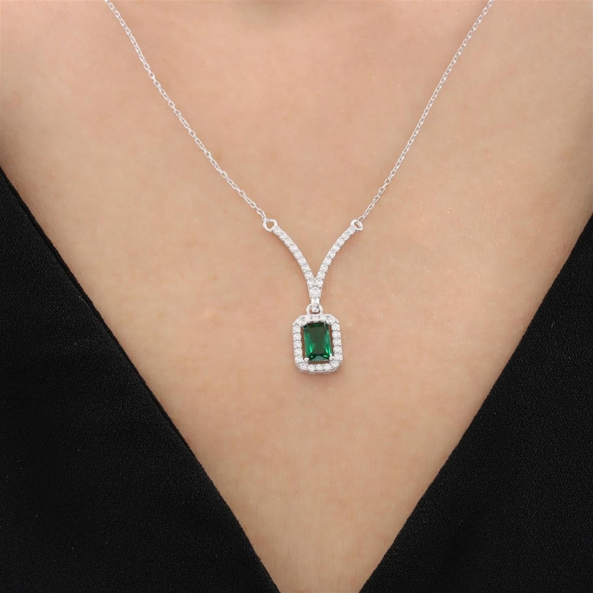 Collar de plata con piedra rectangular verde esmeralda y halo de circonitas