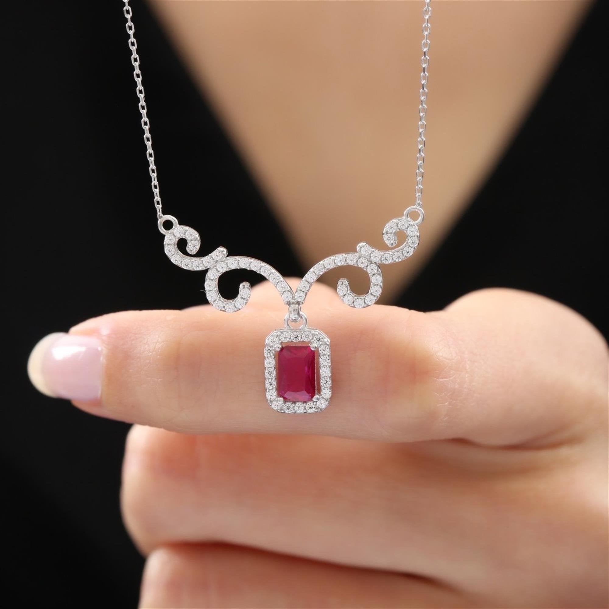 Collar en tono plata con circonita roja baguette y diseño de espirales – joya elegante para eventos especiales