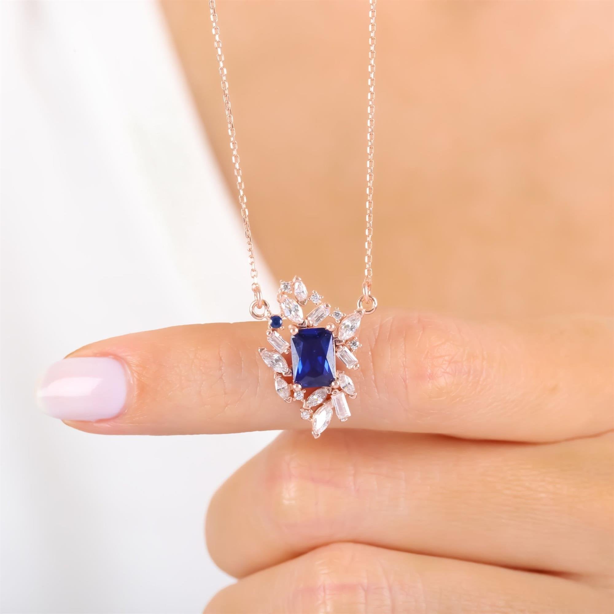 Rose gold plated necklace with synthetic sapphire center stone and CZ cluster design – elegant luxury pendant for women