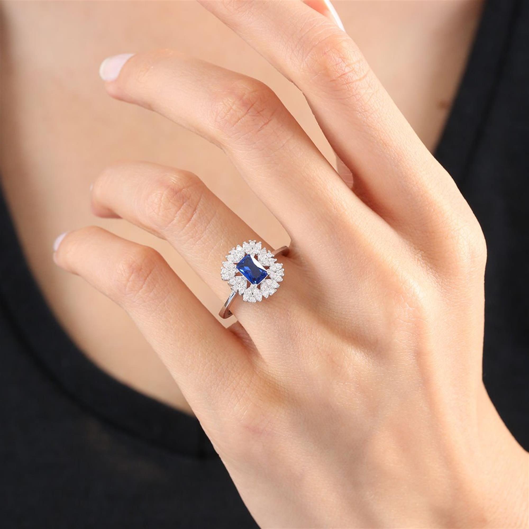 Anillo de plata con zafiro azul baguette y halo de circonitas