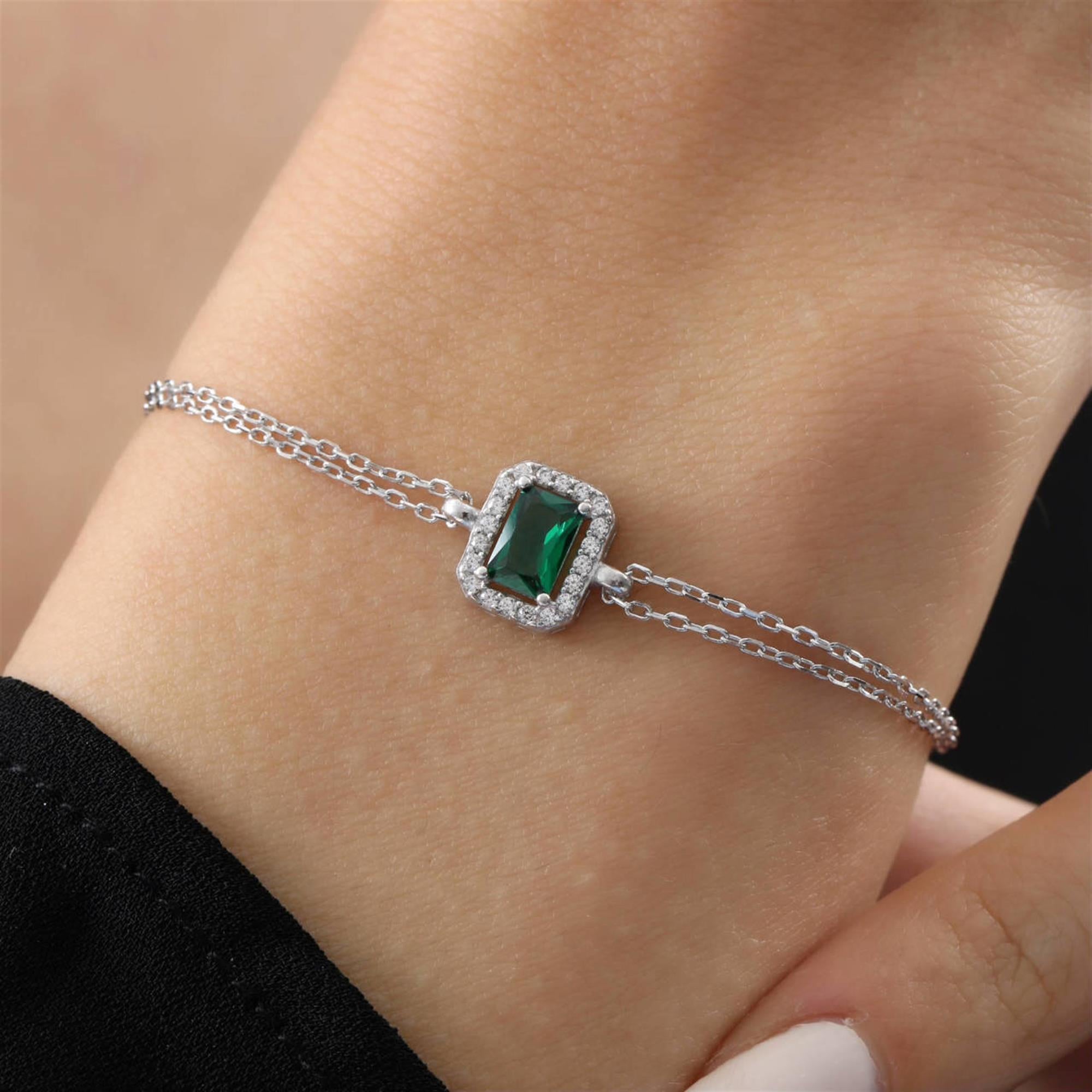 Silver bracelet with rectangular emerald green stone and halo of sparkling zirconia on a double chain