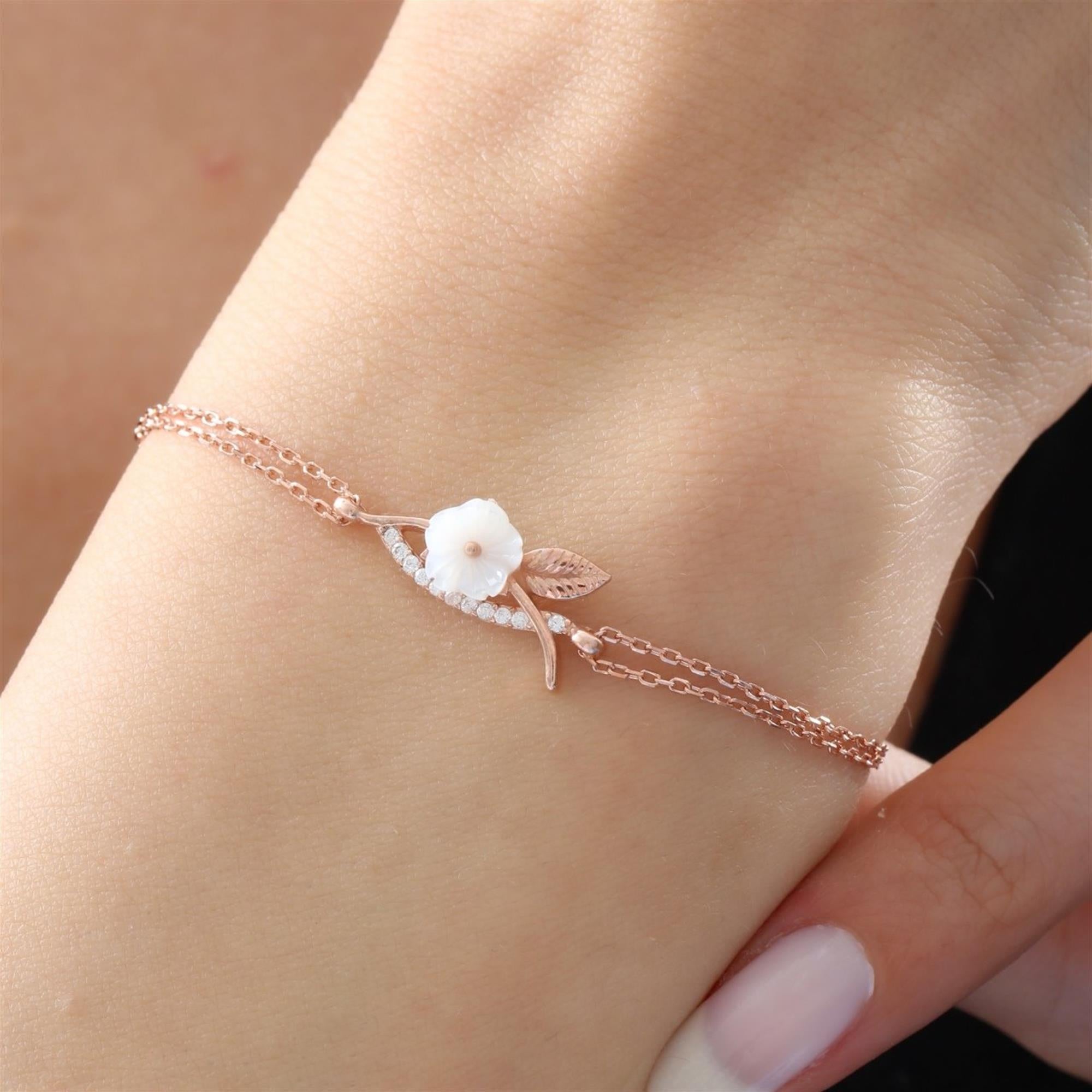 Pulsera de flor de magnolia en oro rosa con nácar y hojas de circonita – accesorio botánico delicado y femenino