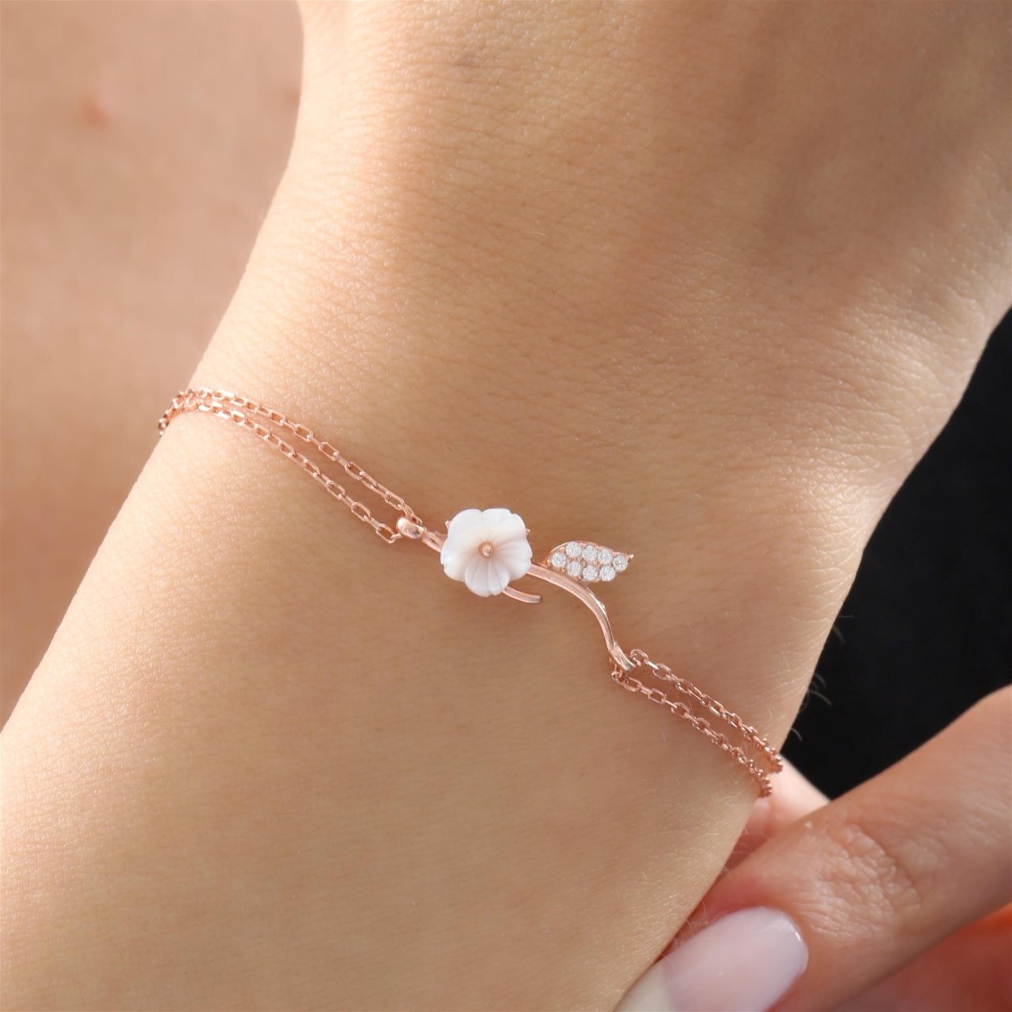 Pulsera rosa con flor blanca de magnolia y hoja brillante en cadena doble