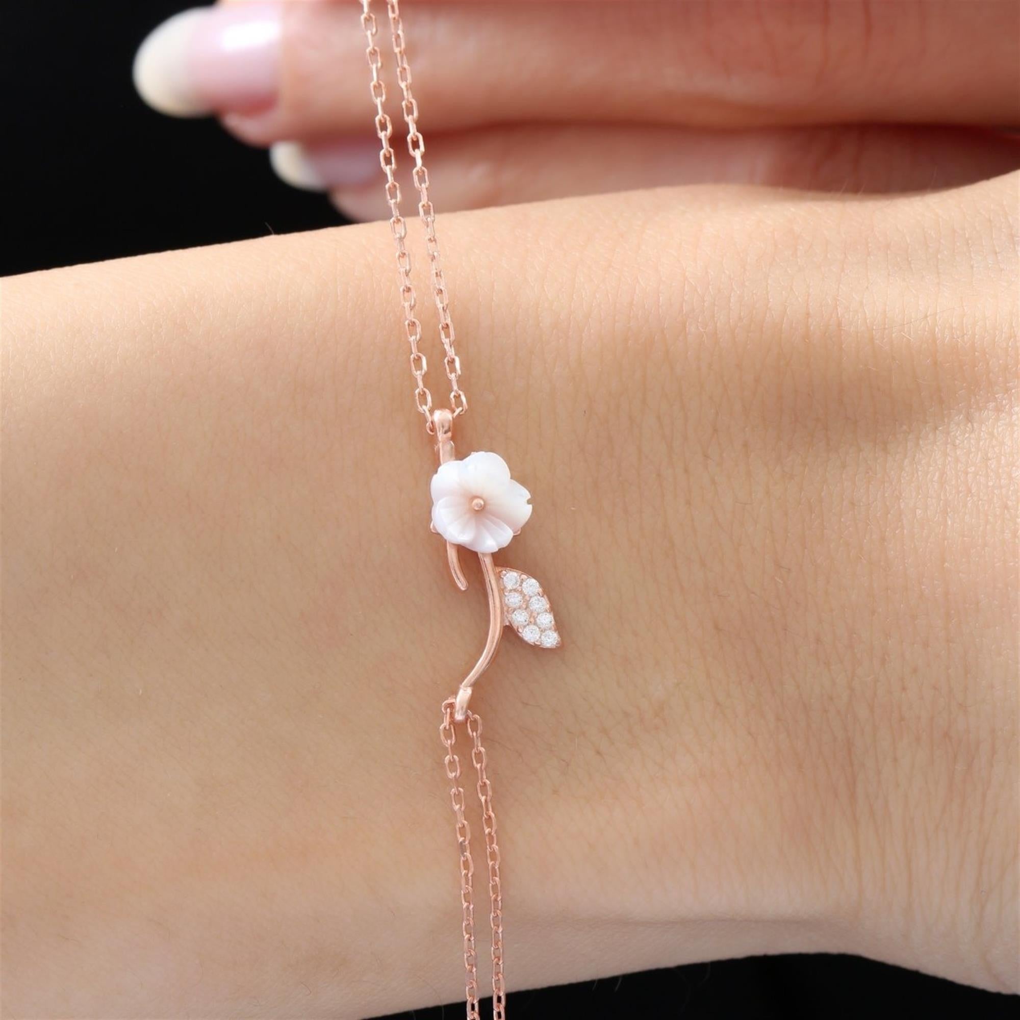 Roségoldenes Armband mit weißer Magnolienblume und funkelndem Blatt an Doppelkette