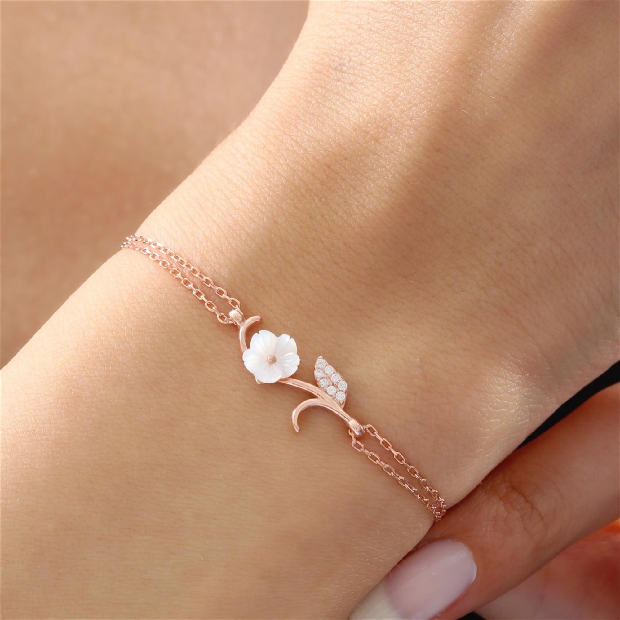 Rose gold bracelet with white magnolia flower and sparkling leaf on a double chain