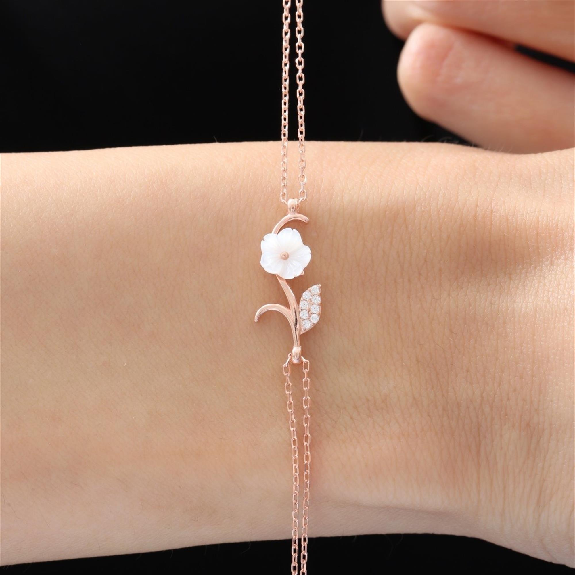 Roségoldenes Armband mit weißer Magnolienblume und funkelndem Blatt an Doppelkette