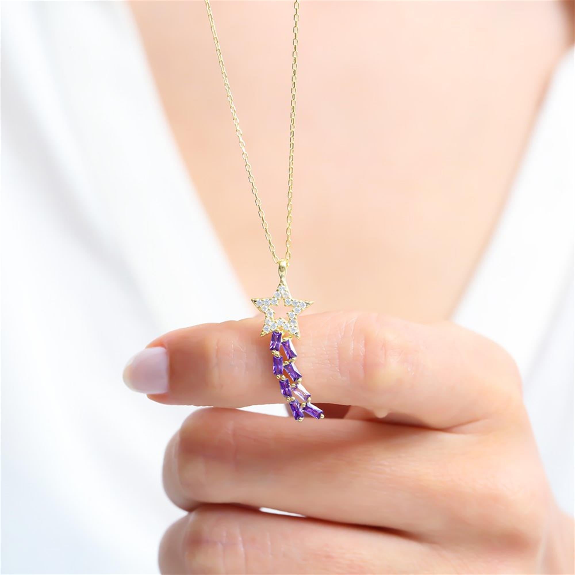 Gold necklace with a sparkling star and amethyst baguette tail – inspired by falling stars and cosmic elegance.