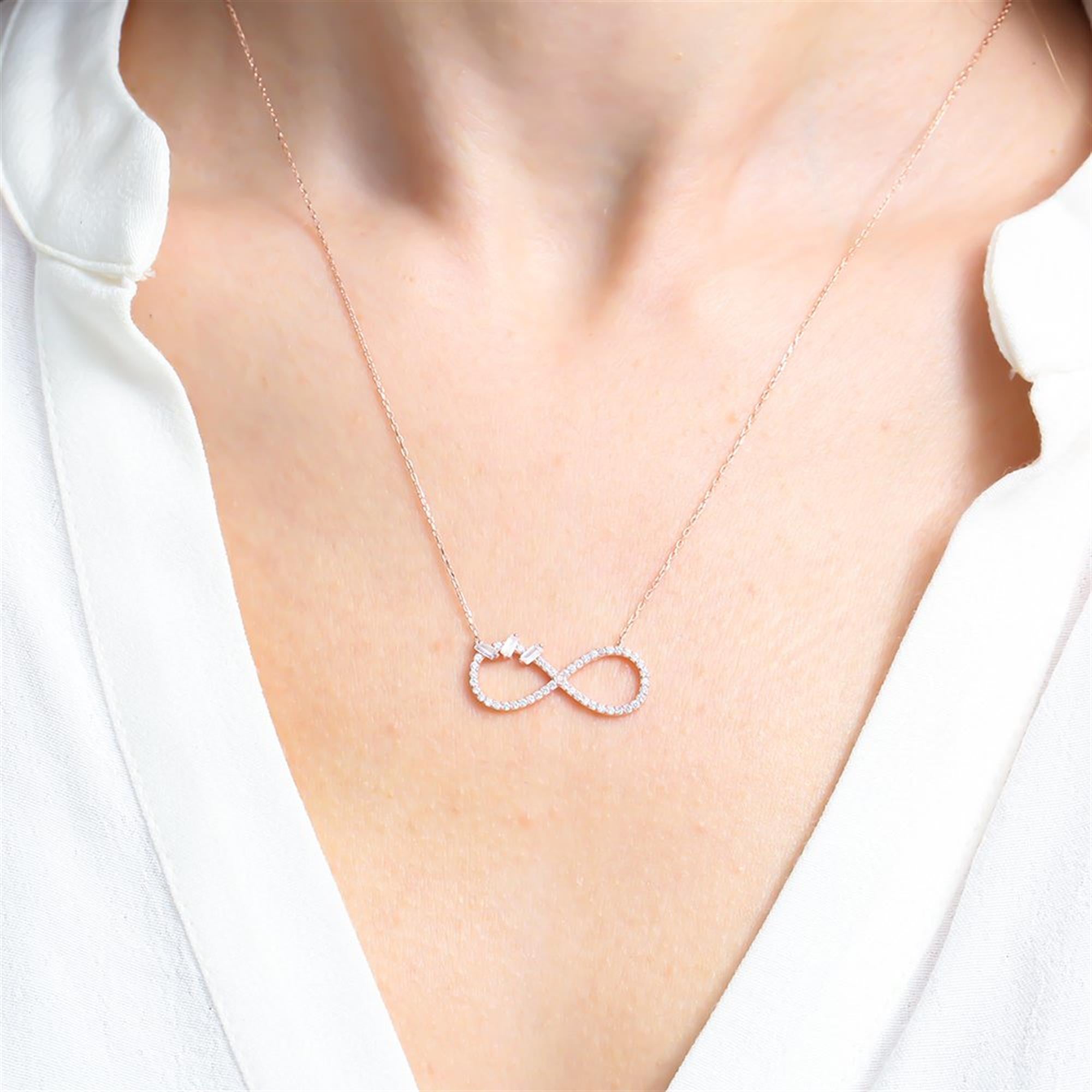 Rose gold infinity necklace with baguette stone accents and sparkling cubic zirconia
