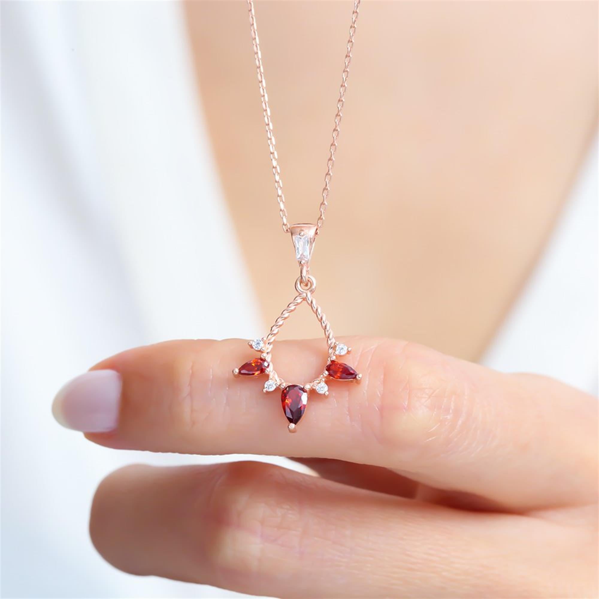 A dazzling rose gold teardrop necklace featuring deep garnet and white zircon stones, perfect for gifting or elegant daily wear.