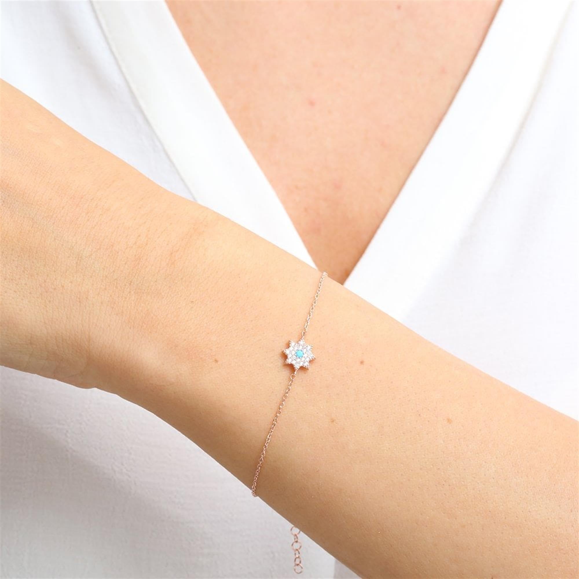 Radiant rose gold starburst bracelet with turquoise center and pavé zirconia – inspired by cosmic elegance.