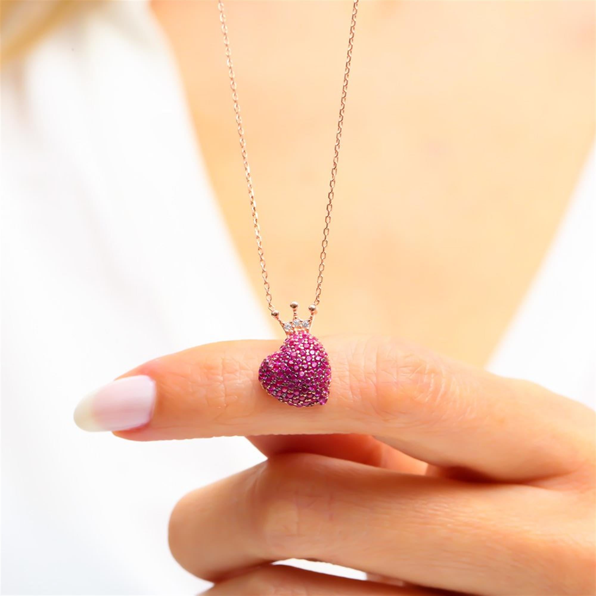 Glamorous fuchsia stone heart necklace in rose gold with a crown detail – a bold statement of love and royalty.