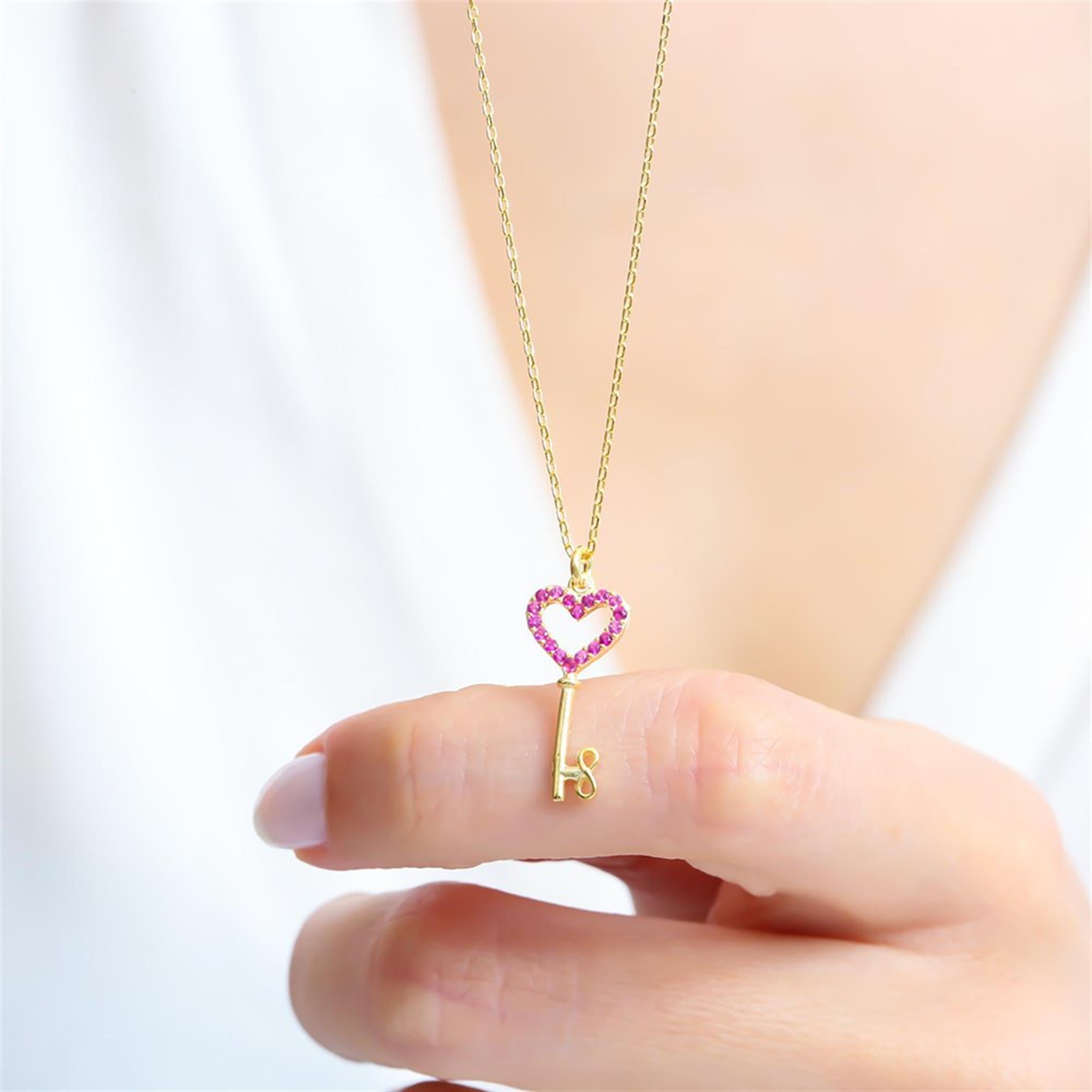 Elegant gold heart key necklace featuring vibrant fuchsia stones on a delicate chain – the perfect romantic gift to symbolize love and connection.