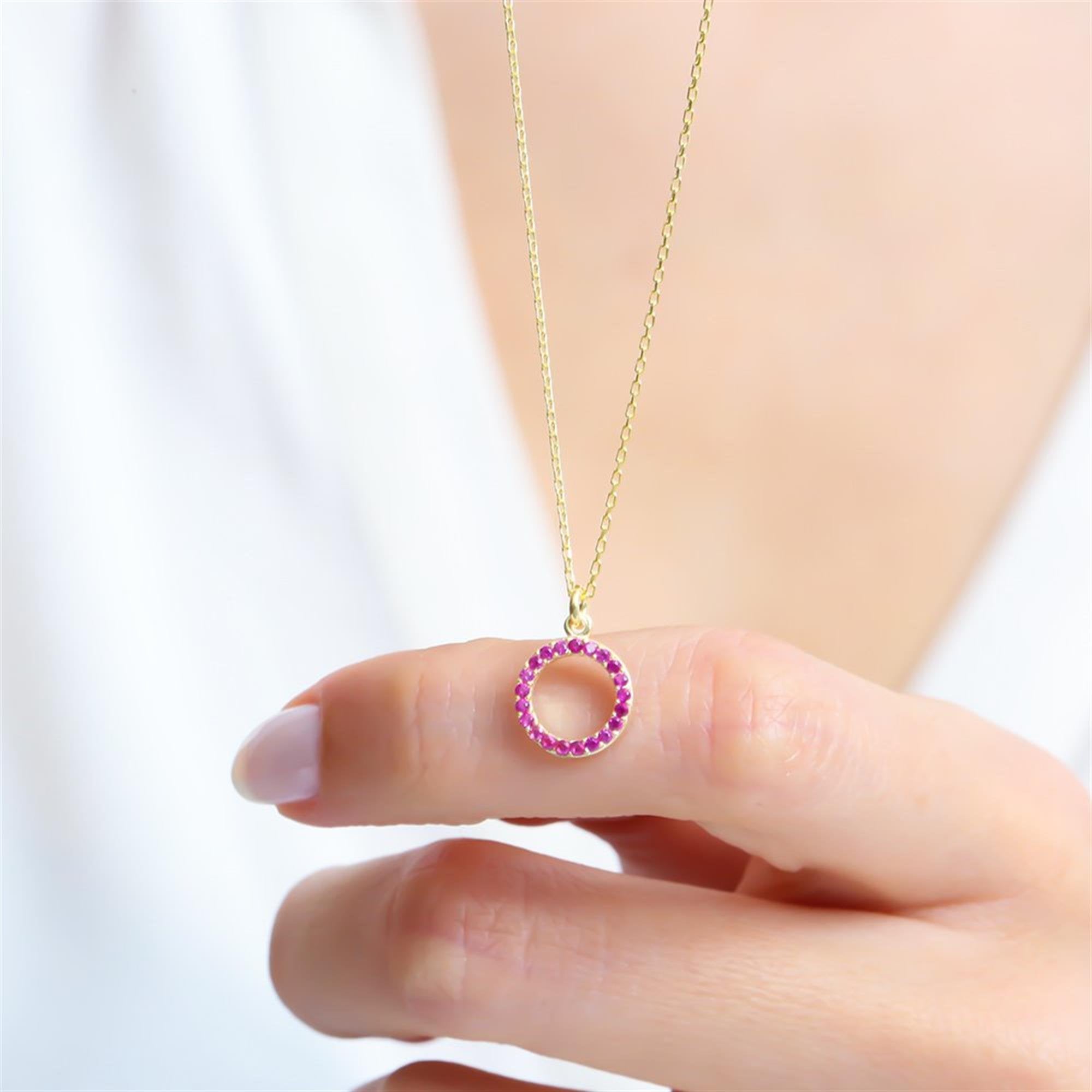 Collar de círculo minimalista bañado en oro con piedras de circonita fucsia – ideal para un look diario elegante.
