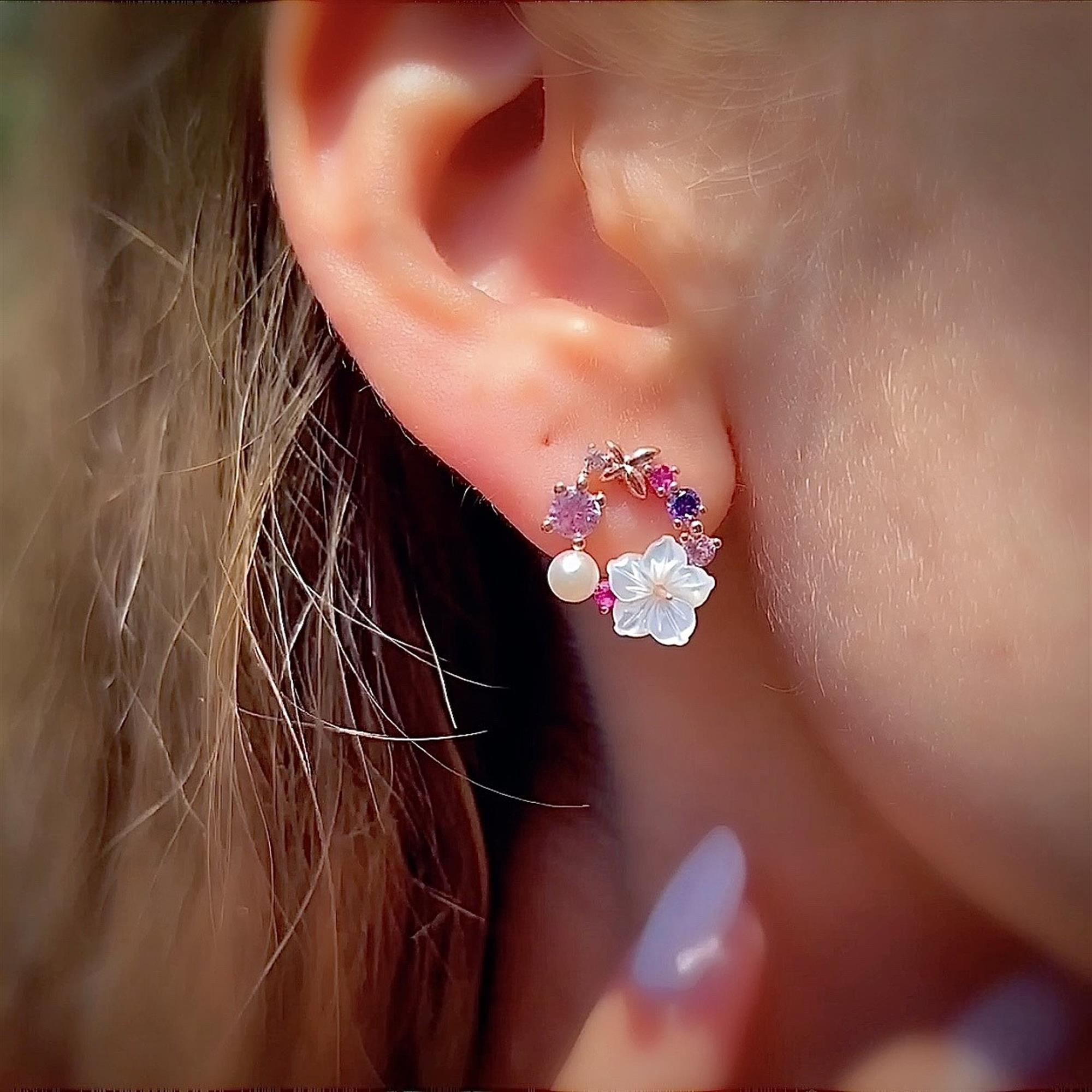 Delicate Italian-style gold hoop earrings adorned with pastel flower stones, a carved floral charm, and a pearl detail – elegant summer look.