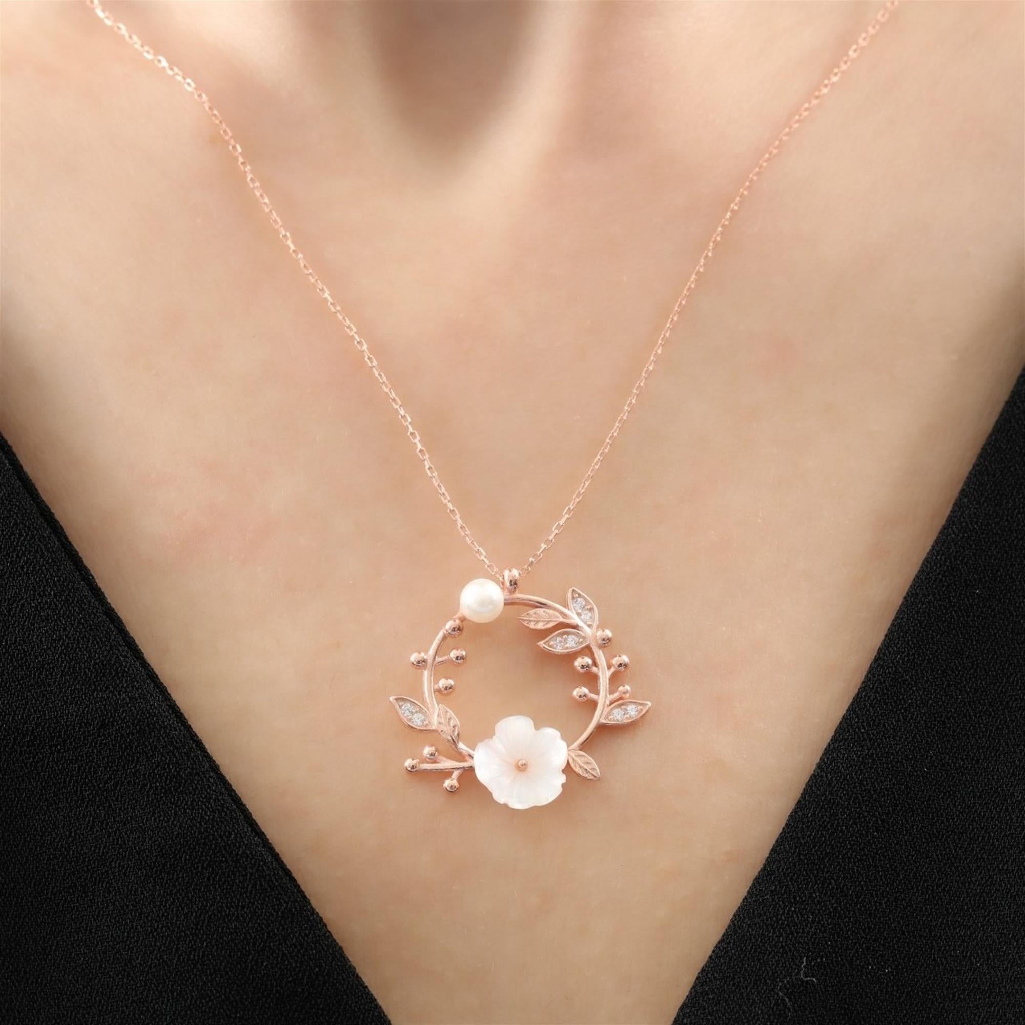 Rose gold necklace with white magnolia flower, crystal leaves, pearl detail and floral bud accents