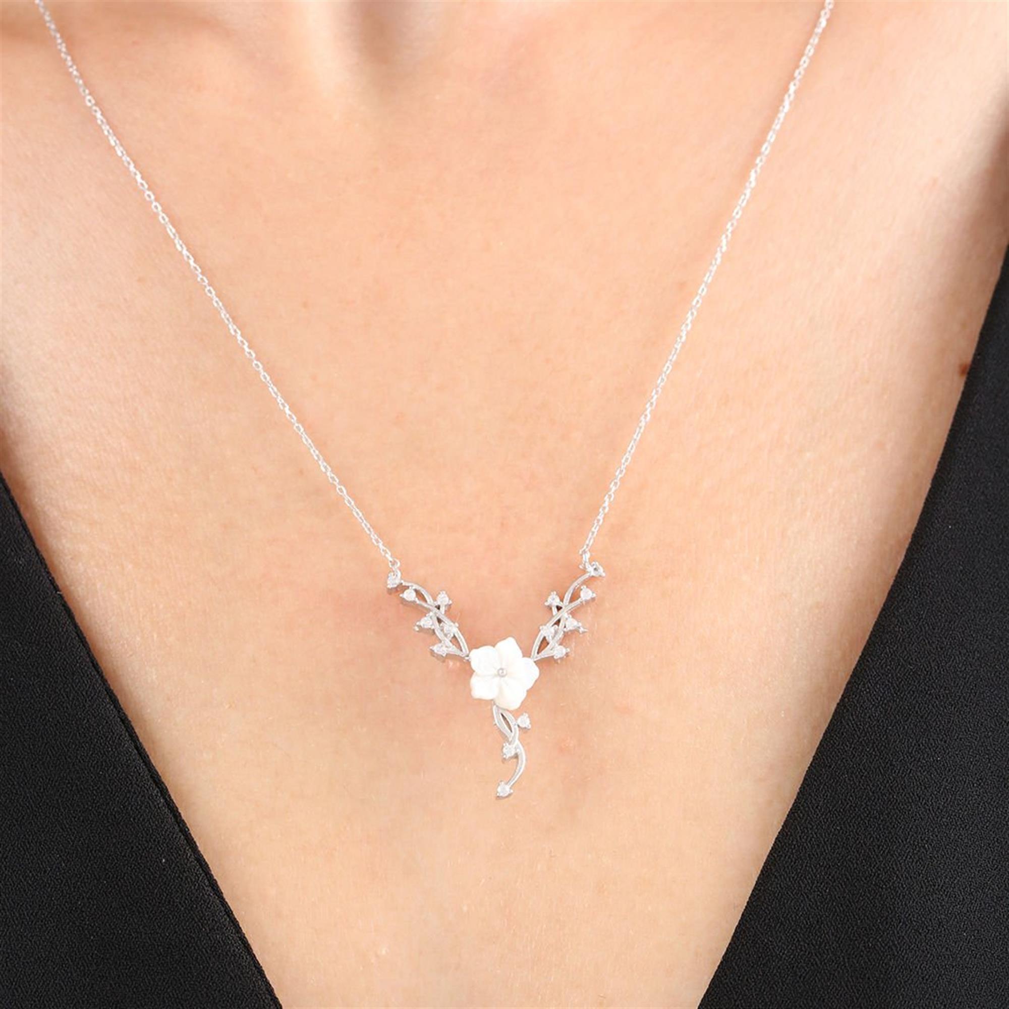 Collar de plata con flor de magnolia blanca y diseño de enredadera con circonitas