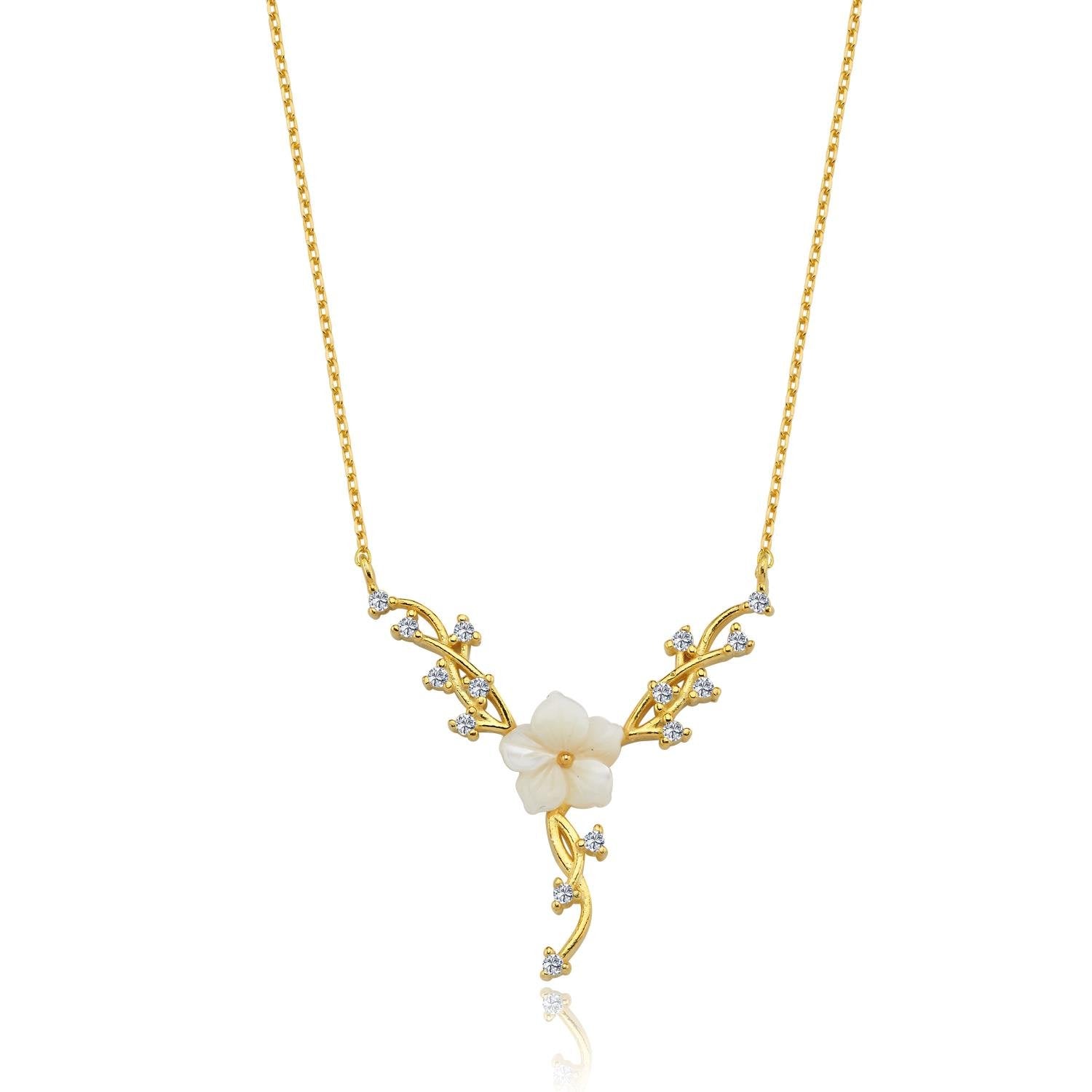 Goldene Halskette mit weißer Magnolienblume und funkelnden Rankenakzenten