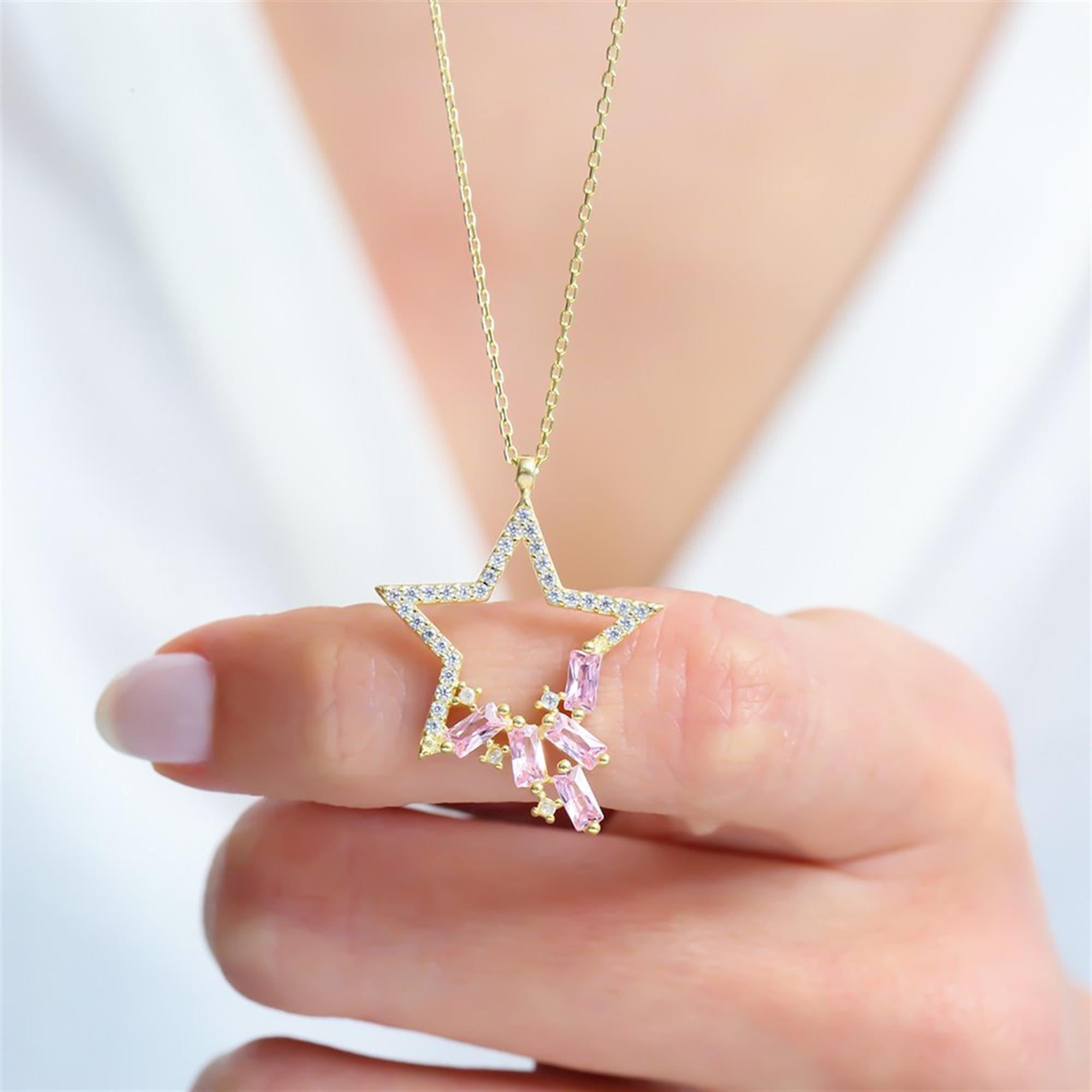 Gold-plated star necklace with dazzling white zircon and pink baguette stones – a magical piece for radiant elegance.