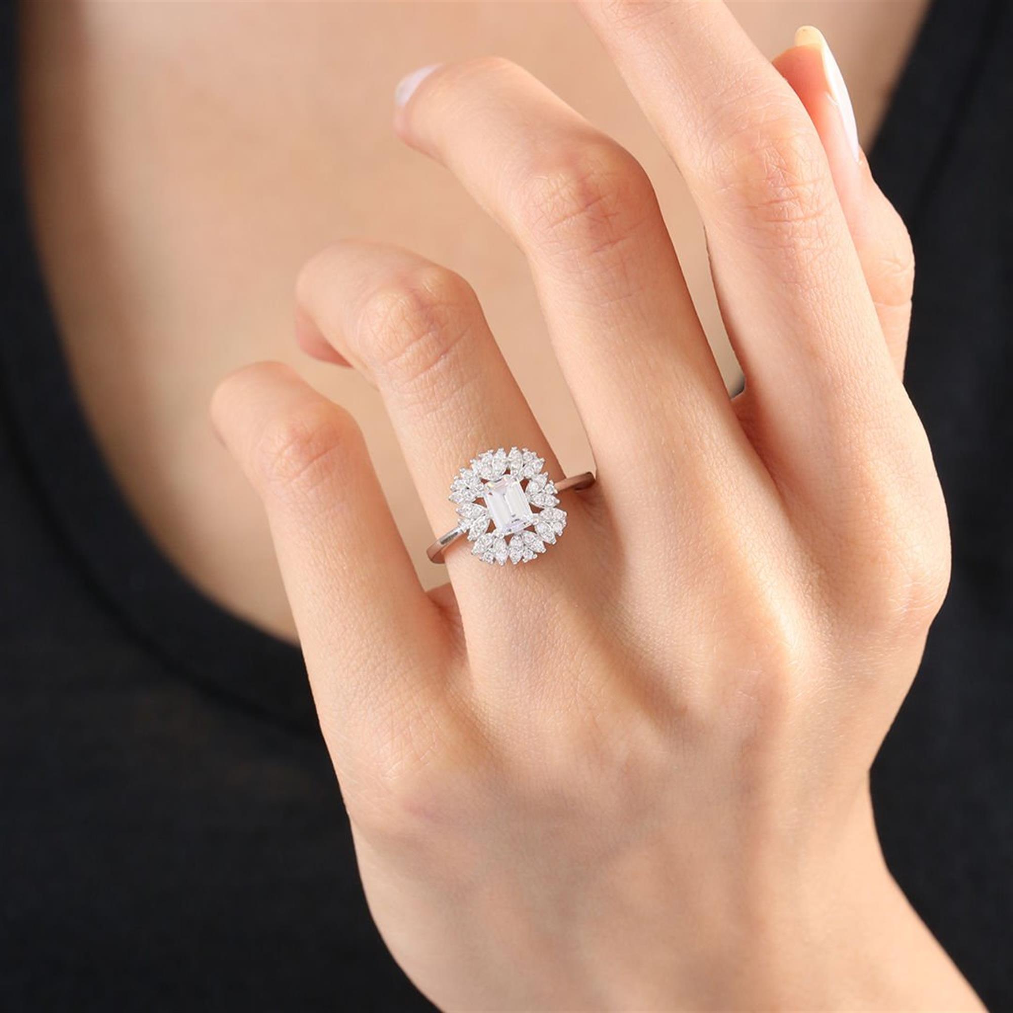 Sterling silver ring with emerald-cut center stone and sparkling halo of zirconia