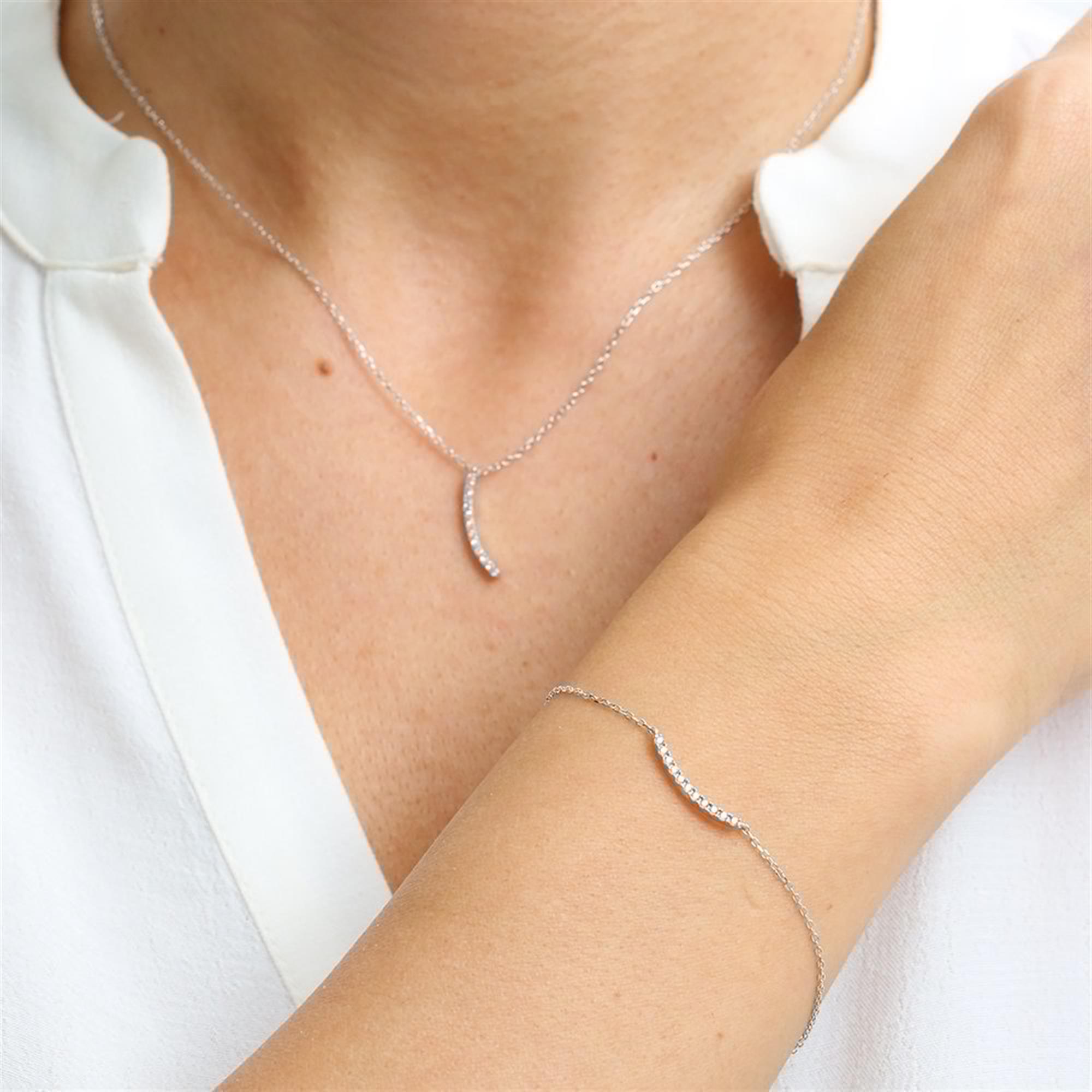 925 sterling silver jewelry set featuring a delicate wave design with diamond-cut zircon stones on both necklace and bracelet.