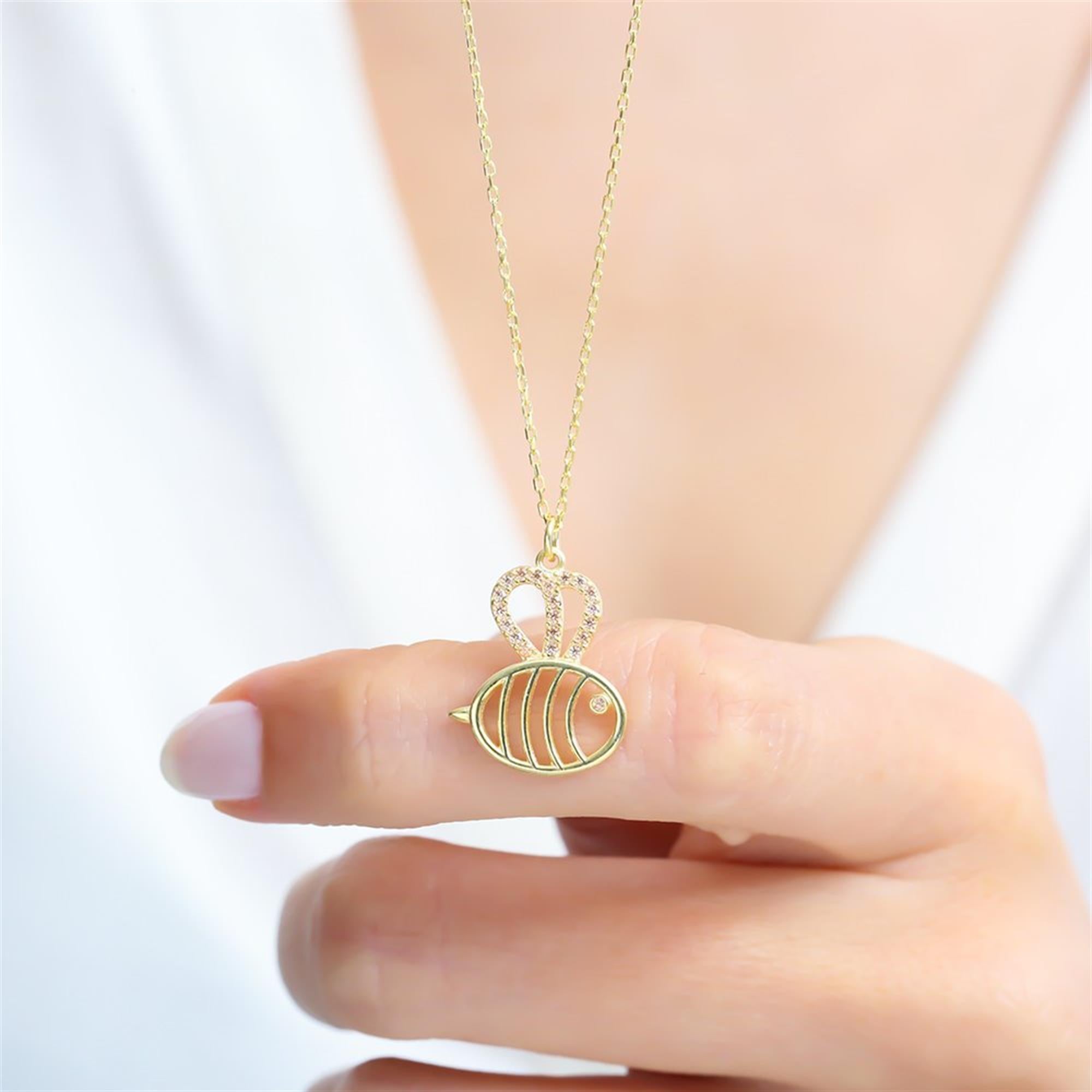 Gold fish necklace with champagne zircon stones and heart-shaped wings – a whimsical and delicate pendant.