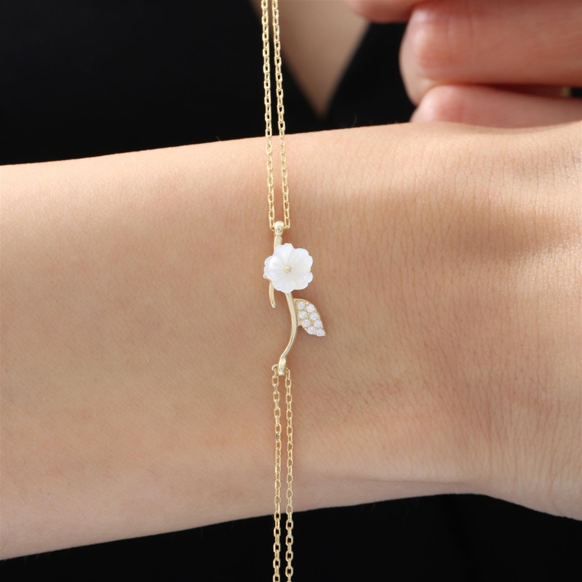 Goldfarbene Armband mit geschnitzter weißer Magnolienblüte und Zirkonia-Blatt – zartes Naturdesign